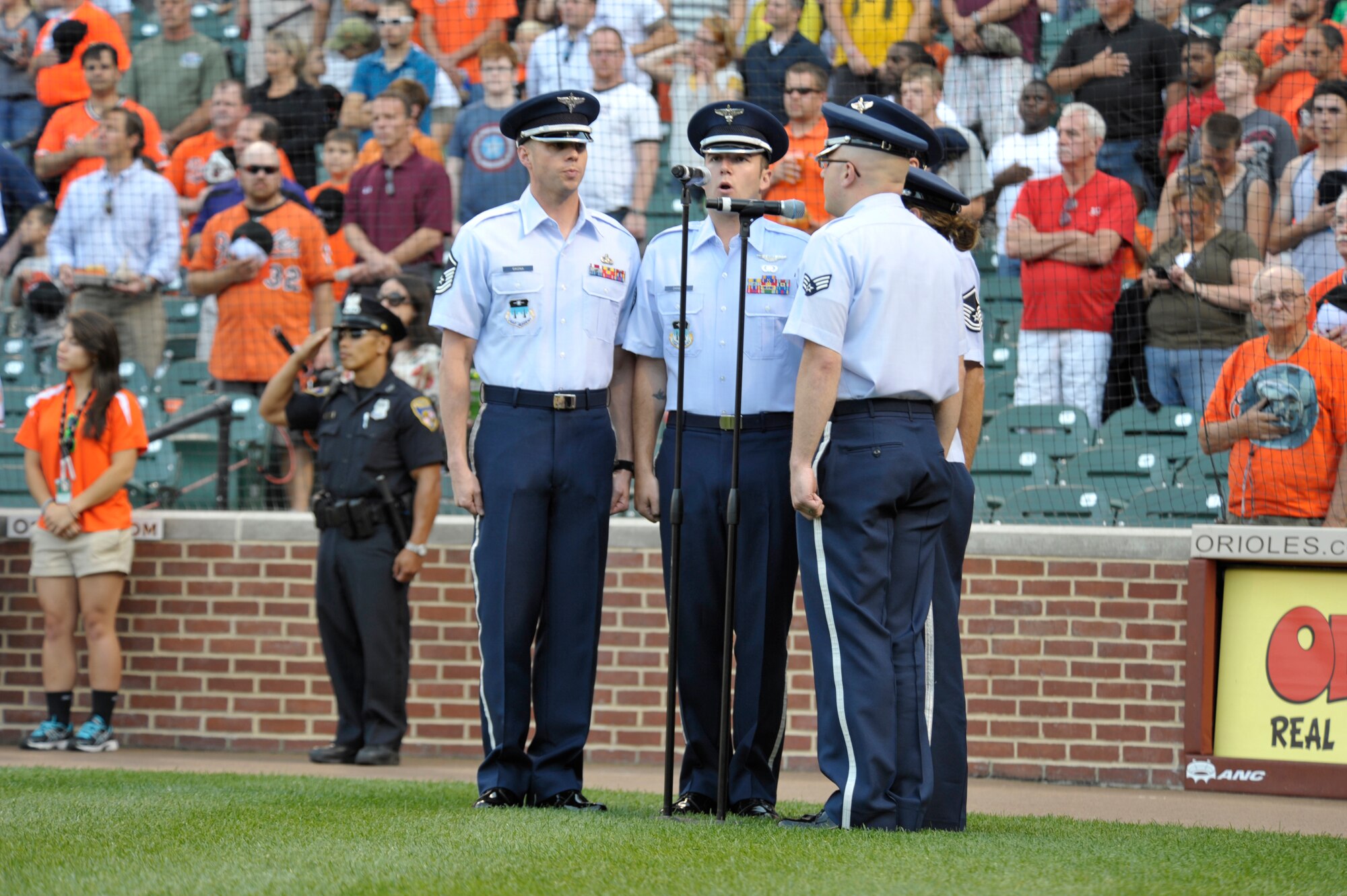 Members of the United States Air Force Academy Band sing the National Anthem June 13, 2012, in front of a crowd of 23, 238 fans at Oriole Park at Camden Yards, Md. The bandsmen perform at numerous locations worldwide in an effort to project a positive Air Force image through music. (U.S. Coast Guard photo by Petty Officer 3rd Class Matthew Masaschi)