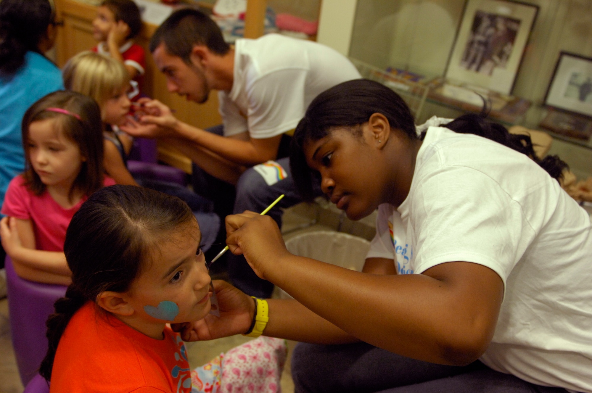 SHAW AIR FORCE BASE, S.C. - Juanita Credle volunteered to apply face paint onto children?s cheeks at the Read-ilious Fair at the Shaw Air Force Base, S.C., library, June 12, 2012,. The summer reading program for children, called, ?Reading is so Delicious?  Over 170 participants arrived at the library and the kids were able to beaded necklaces out of noodles and play on a bouncy castle. The program will continue until July 26 when there will be an award ceremony for all the participants. (U.S. Air Force photo by Airman 1st Class Krystal M. Jeffers/Released)