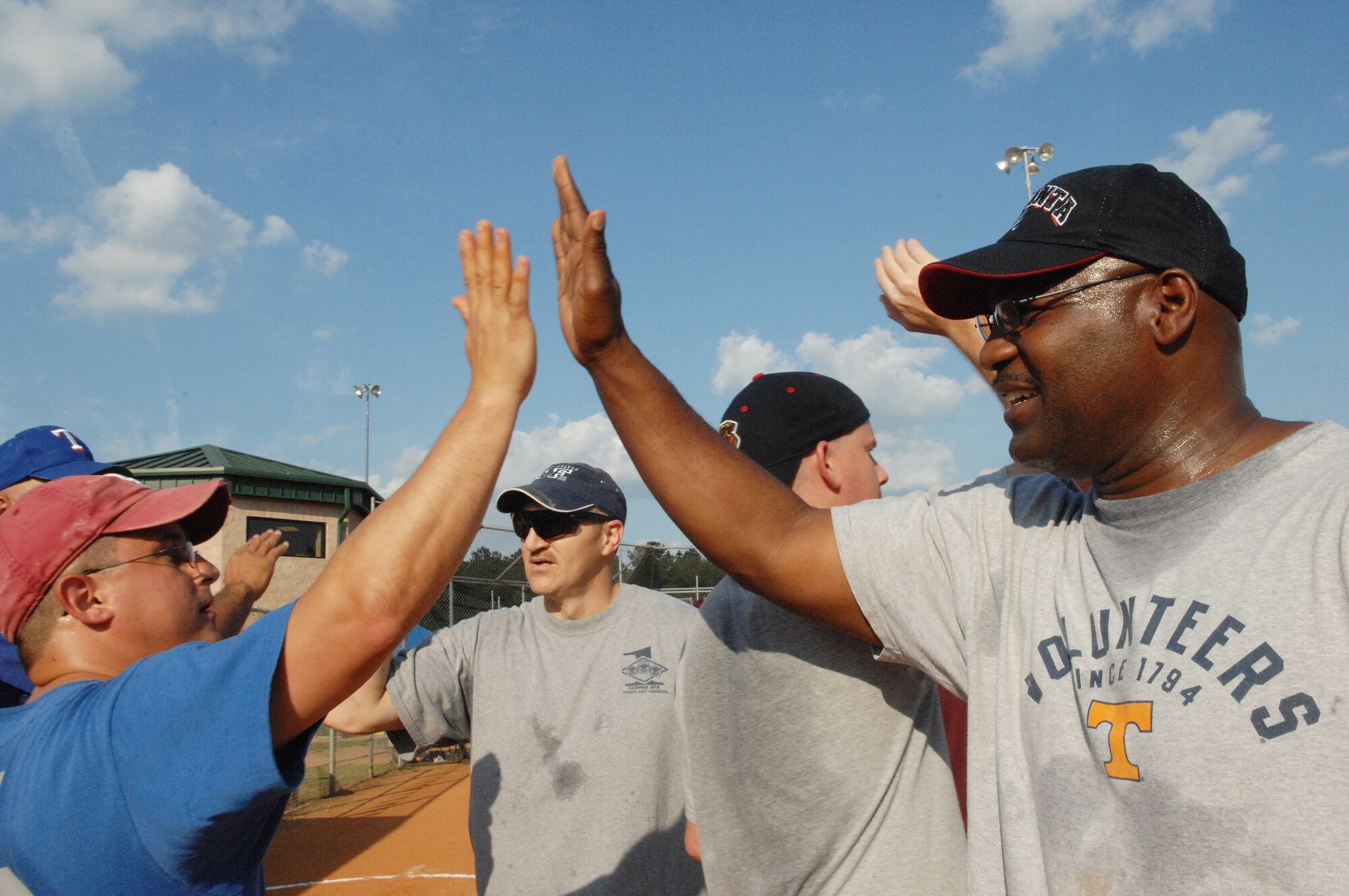 U.S. Air Force Chief Master Sgt. Richard Barbee (right) 20th Maintenance Group weapons manager, high fives Chief Master Sgt. George Richey, 20th Mission Support Group superintendent, at the Chiefs vs. Eagles softball game, Shaw Air Force Base, S.C., June 18. 2012.  The Chiefs were the 2012 winners.(U.S. Air Force Airman Nicole Sikorski/Released