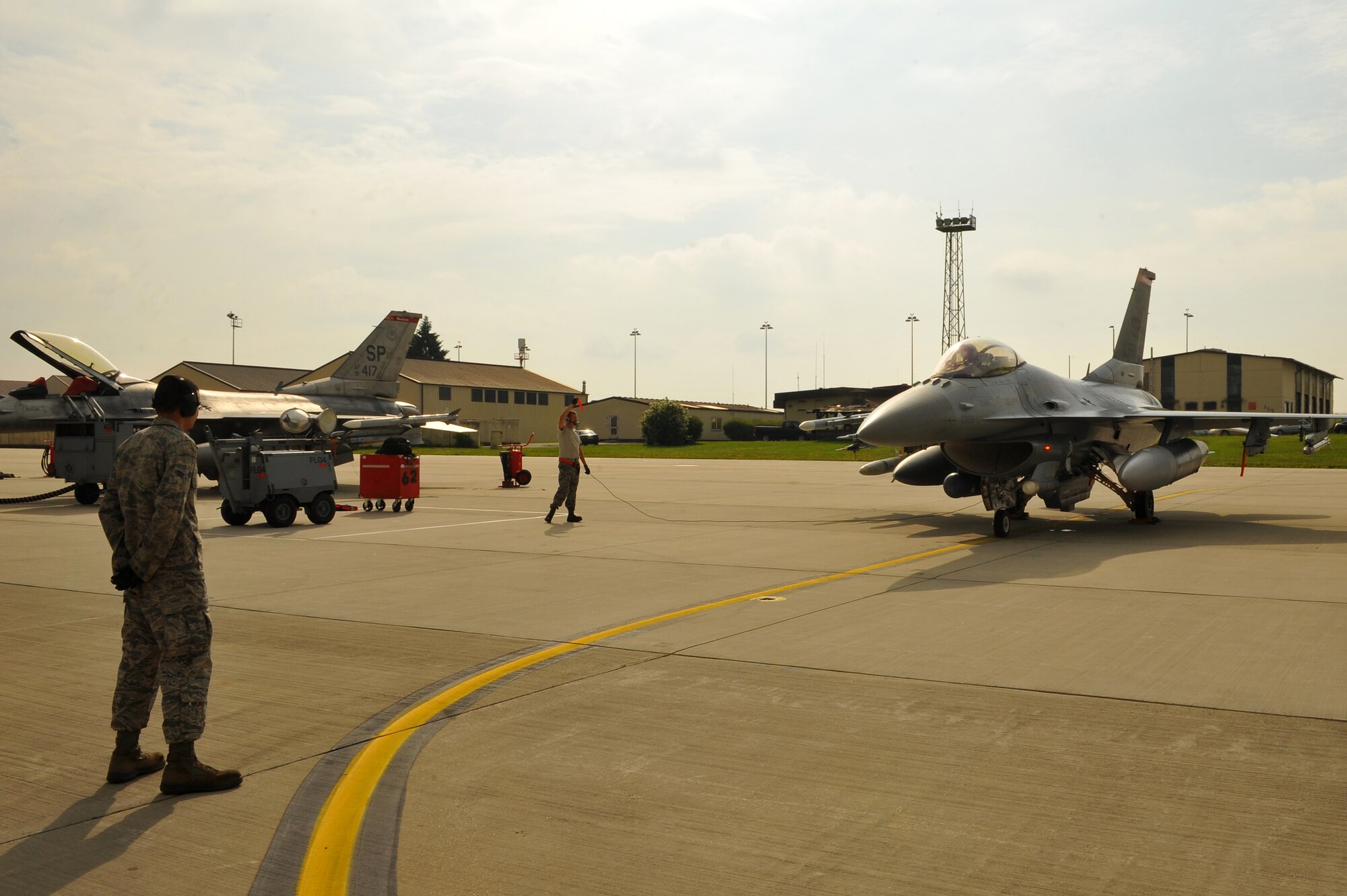 SPANGDAHLEM AIR BASE, Germany – Airman 1st Class William Seay, left, 480th Aircraft Maintenance Unit weapons load crew member, and Airman 1st Class Joshua Berard, 480th AMU crew chief, complete a standard aircraft launch procedure for an F-16 Fighting Falcon on Ramp 4 here June 19. The 480th AMU plays a vital role in supporting the F-16’s combat training mission, which prepares them for regional defense and air superiority. (U.S. Air Force photo by Airman 1st Class Dillon/Released)