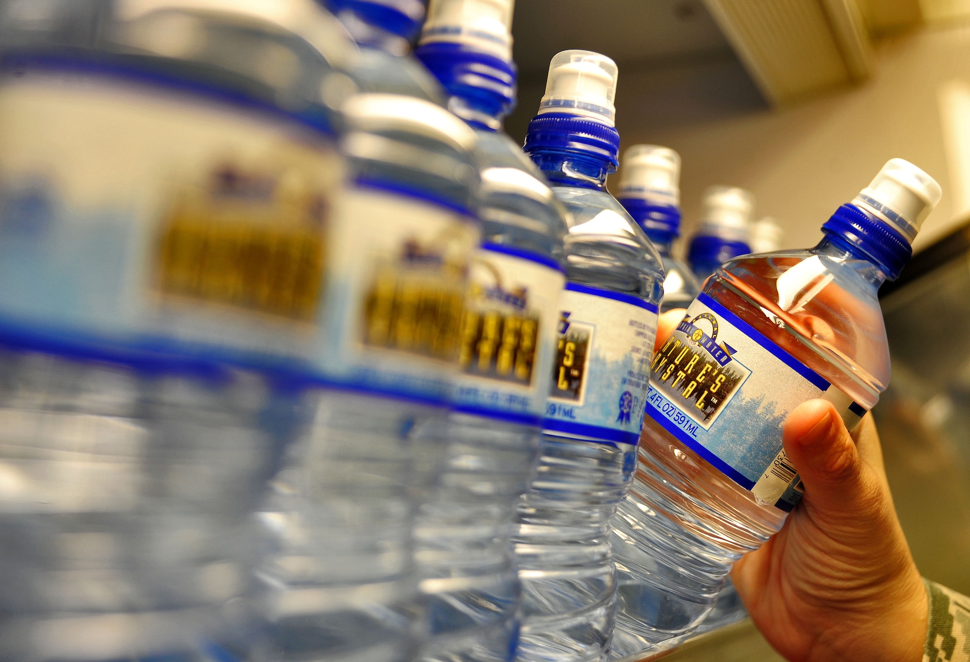 WHITEMAN AIR FORCE BASE, Mo. -- An Airman pulls a bottle of water off a shelf at the Whiteman Fitness Center June 6. The amount of water someone drinks varies depending on a person’s weight and activity level. (U.S. Air Force photo/Senior Airman Nick Wilson) (Released)