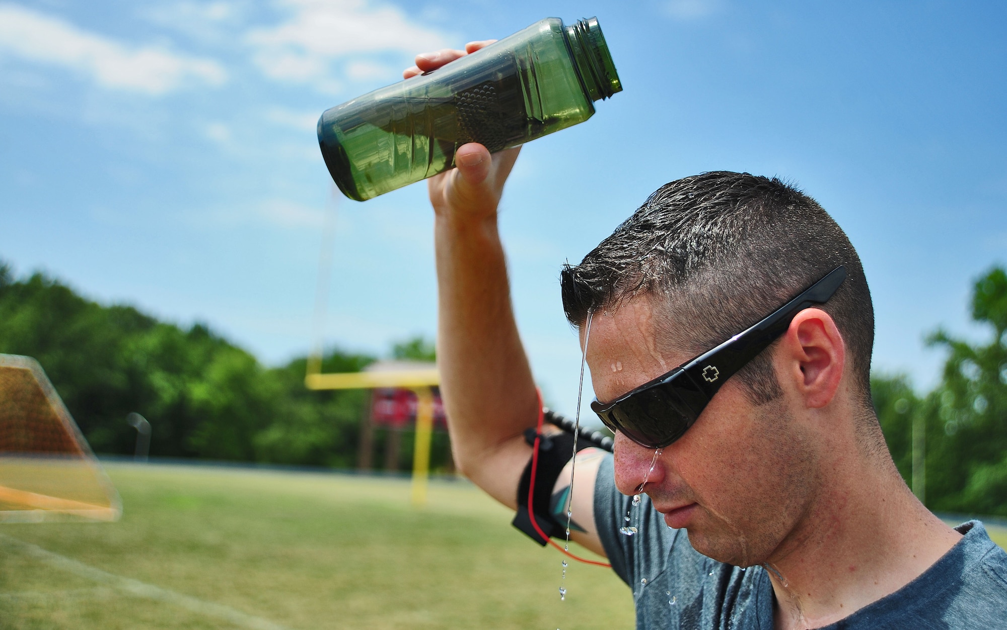WHITEMAN AIR FORCE BASE, Mo. -- Staff Sgt. Thomas Waters, 509th Comptroller Squadron financial management comptroller, pours water over his head to cool his body temperature after a physical training session June 6. The amount of water a person drinks plays an important role in conservation of body temperature, according to the American College of Sports Medicine website. (U.S. Air Force photo/Senior Airman Nick Wilson) (Released)