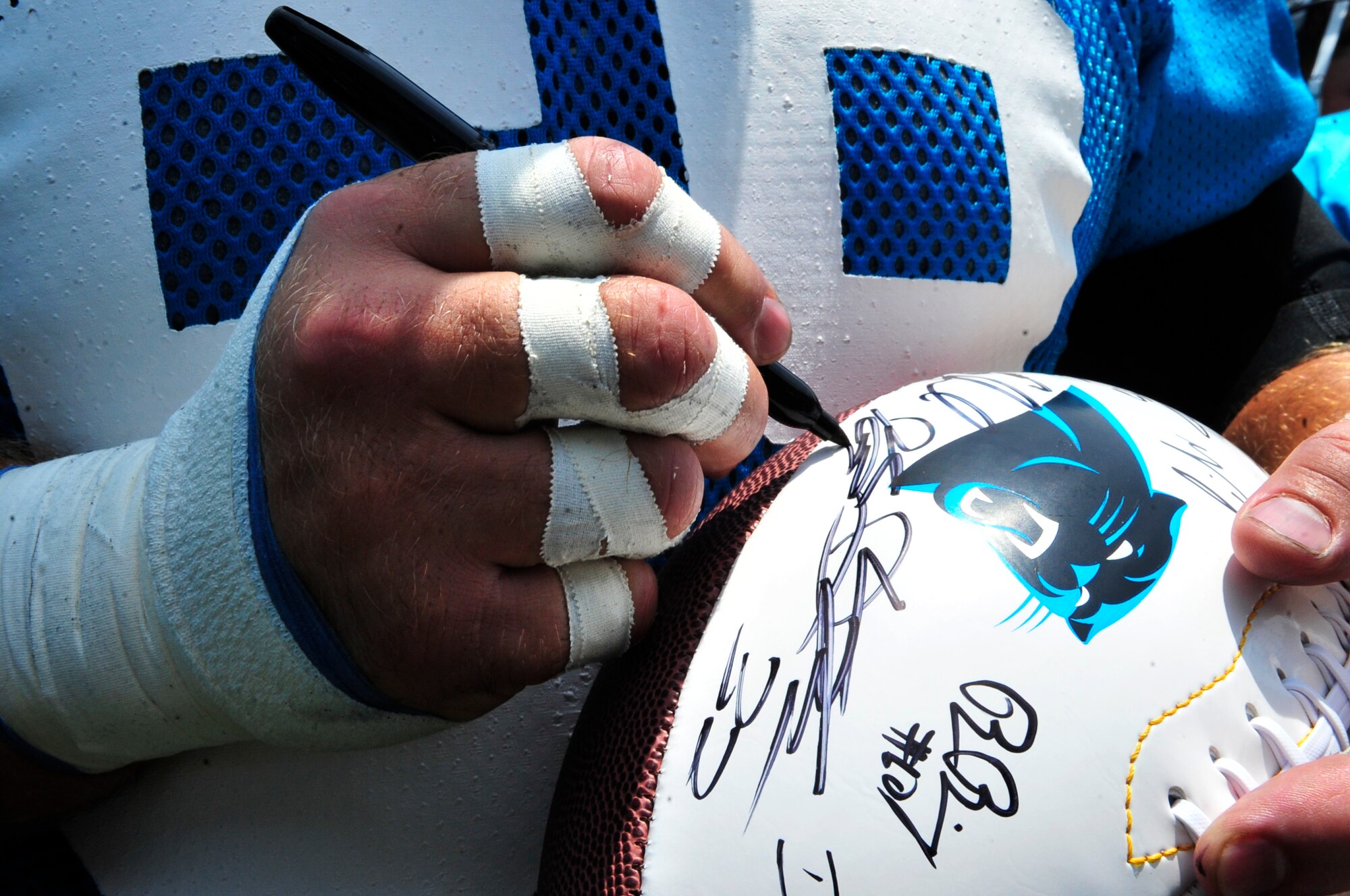 Thomas Davis, Carolina Panthers linebacker, signs autographs with his team mates at the Bank of America Stadium, Charlotte, N.C., June14, 2012. This event allowed fans to watch the last Panthers minicamp training practice.(U.S. Air Force Airman Nicole Sikorski/Released)
