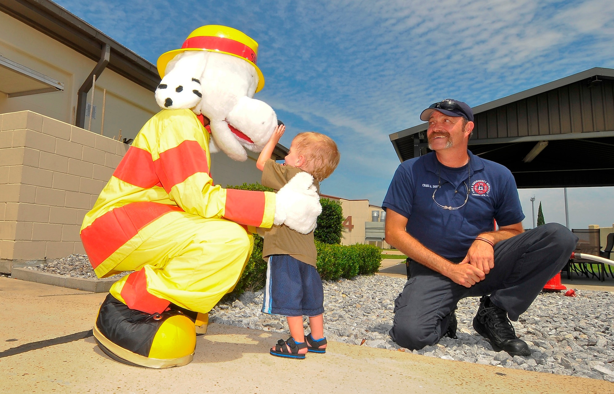 Craig Devoy, 325th Civil Engineer Squadron firefighter, introduces Jaxson to Sparky the fire dog during his visit to the fire department while on his tour of Tyndall. Jaxson was born with Russell-Silver syndrome, a genetic growth disorder characterized by slow growth before and after birth. (U.S. Air Force photo by Chris Cokeing)