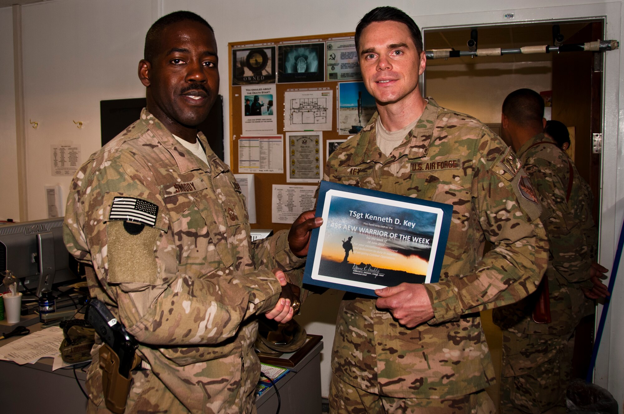 CMSgt. Marcus Snoddy, 455th Air Expeditionary Wing command chief, presents the Warrior of the Week award to TSgt Kenneth Key, NCOIC of 455th Medical Information Systems at Bagram Airfield, Afghanistan, June 19, 2012. Key leads the IT help desk for the Craig Joint Theater Hospital, the most intensive Role III medical facility in USCENTCOM. He supervises a joint team responsible completeing all CJTH IT work orders, managing 335 user accounts on two networks and maintaining six separate systems.  (U.S. Air Force photo/TSgt Shawn McCowan)