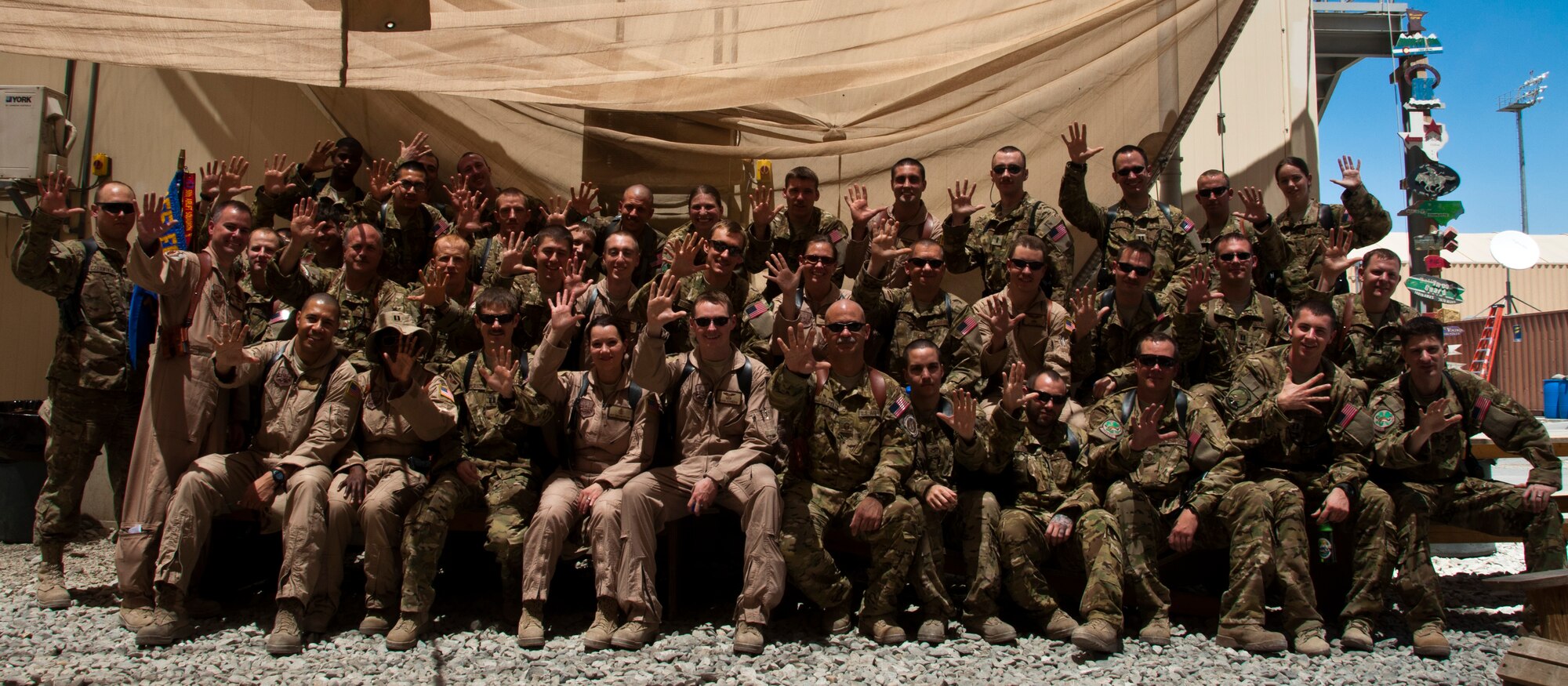Members of the 50th Airlift Squadron from Little Rock Air Force Base, Ark., raise a “High Five” to their stateside counterparts as they celebrate their unit’s 70-year-history while deployed as the 774th Expeditionary Airlift Squadron at Bagram Airfield, Afghanistan. (U.S. Air Force photo/TSgt Shawn McCowan)