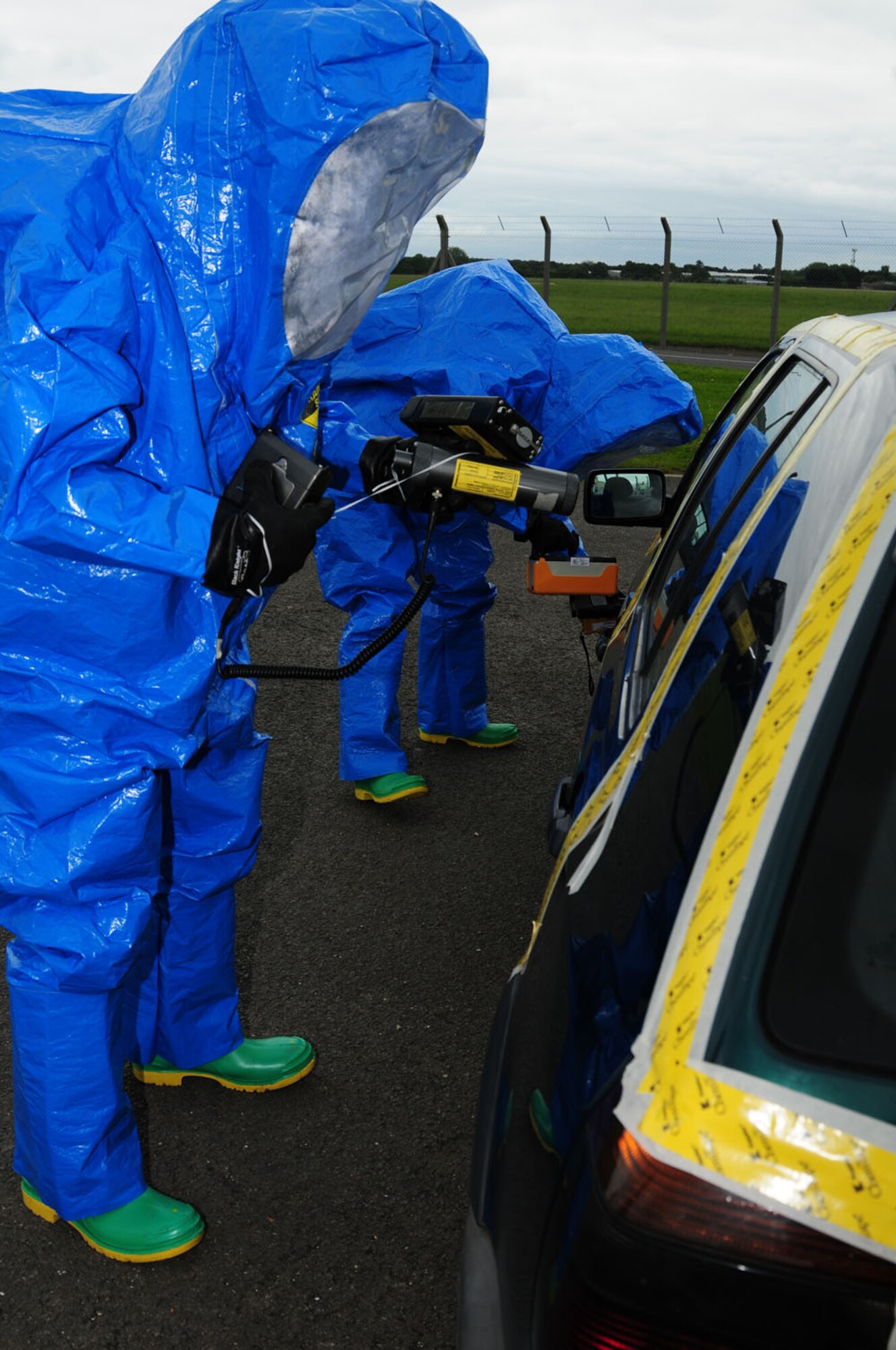 RAF MILDENHALL, England -- Senior Airman Scott Floyd, a reservist with the 434th Civil Engineer Squadron, Grissom Air Reserve Base, Ind., and Airman 1st Class Marco Misko, 100th Civil Engineer Squadron, perform sampling procedures on a suspect vehicle sealed with tape during a hazardous materials response exercise here June 12, 2012. A group of reservists from Grissom ARB were here working and training with the 100th CES and the exercise scenario consisted of a chemical suicide in a vehicle. (U.S. Air Force photo/Karen Abeyasekere)