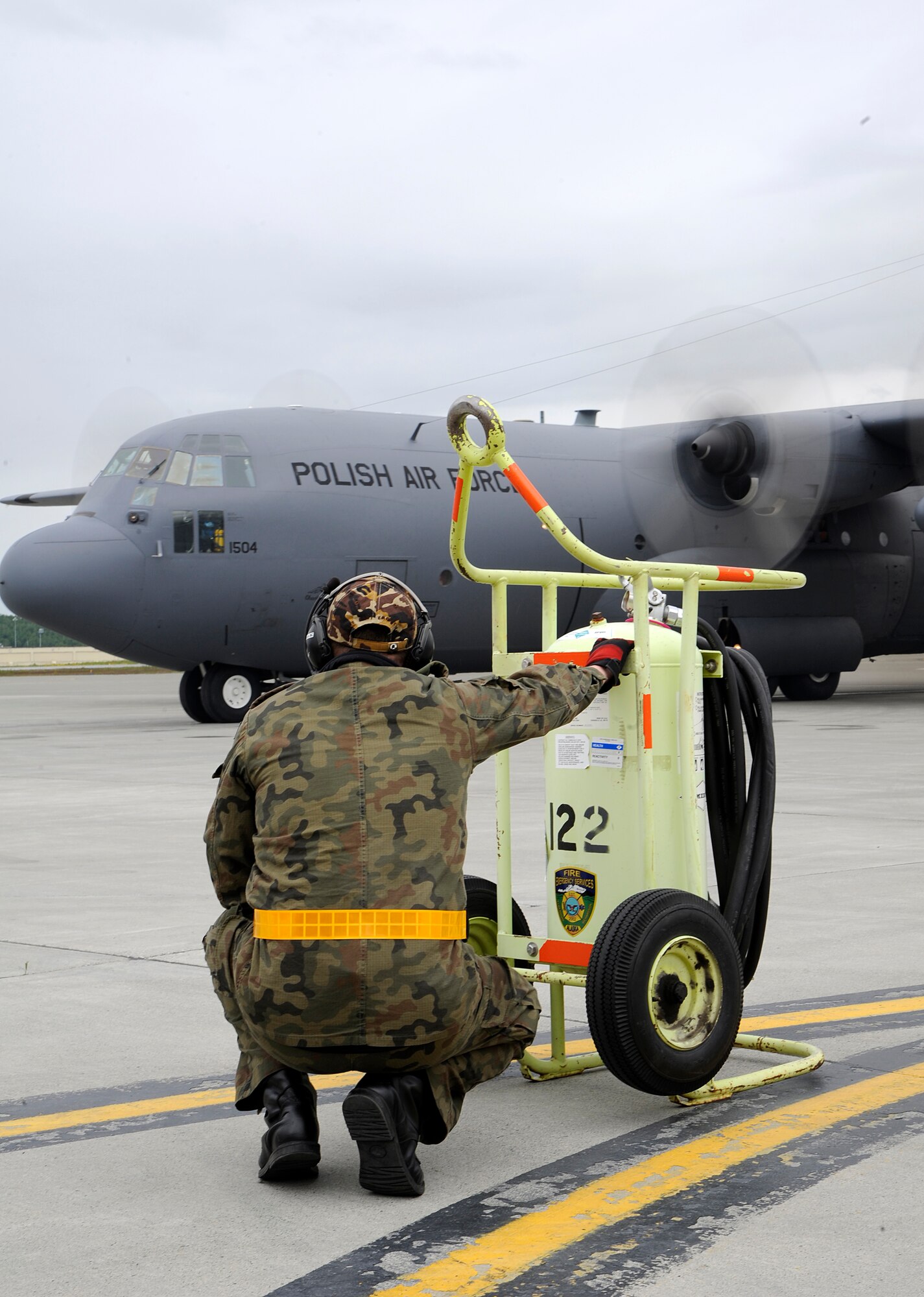 A member of the Polish air force C-130 Hercules crew watches the aircraft taxi to the runway during Red Flag-Alaska on Joint Base Elmendorf-Richardson June 13, 2012. The goal of Red Flag-Alaska is to provide each aircrew with vital first missions to increase their chances of survival in combat environments.