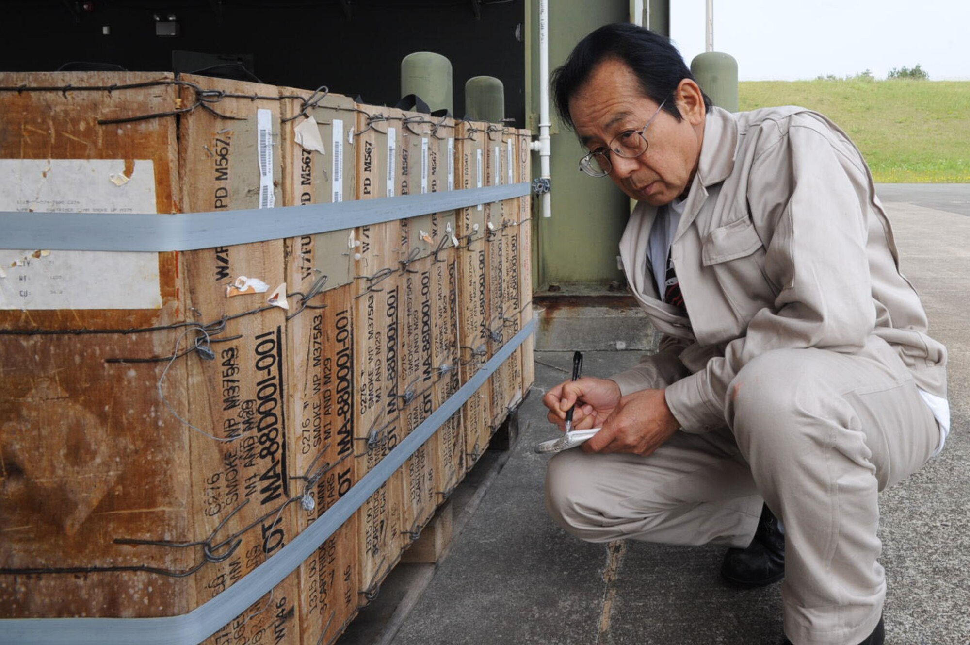 Rikro Tanimoto, Japanese palletization team member, documents unserviceable munitions prepared for shipping at Misawa Air Base, Japan, June 19, 2012. Gaining storage space is one reason to ship excess unserviceable munitions to outside bases with more room. (U.S. Air Force photo by Airman Kenna Jackson/Released)