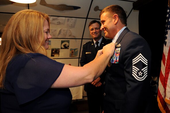 Cornelia Brantley, right, affixes a retirement pin to Chief Master Sgt. John Brantley's lapel during his retirement ceremony as his brother-in-law, retired Col. Randy Borg presides, May 18, 2012, at Barksdale Air Force Base, La. During their 24-year marriage, the couple has made it through some of the most difficult situations the military can present to family members. (U.S. Air Force photo/Senior Airman Brigitte N. Brantley)