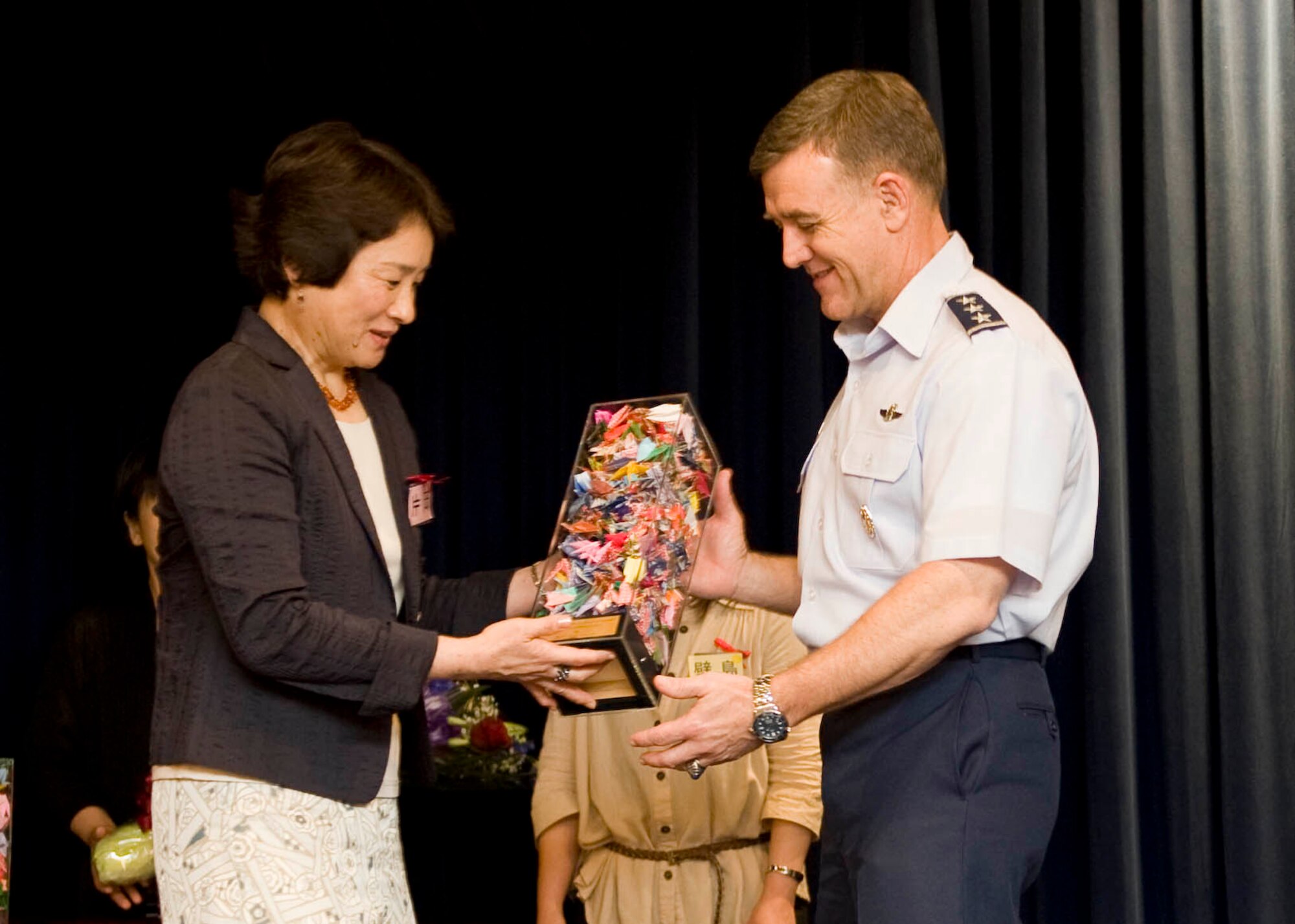 YOKOTA AIR BASE, Japan -- Mrs. Setsuko Kataoka, wife of Gen. Haruhiko Kataoka, Chief of Staff of the Japan Air Self-Defense Forces, gives a collection, gives a collection of paper cranes to Lt. Gen. Burton Field, U.S. Forces, Japan and 5th Air Force commander, during a Masumi Kai Spouse event held at Yokota Air Base, Japan, on June 14, 2012. The cranes were given as a symbol of their appreciation for the U.S. Armed Forces' contributions and assistance to the people of Japan during Operation Tomodachi. (U.S. Air Force photo by Senior Airman Andrea Salazar) 