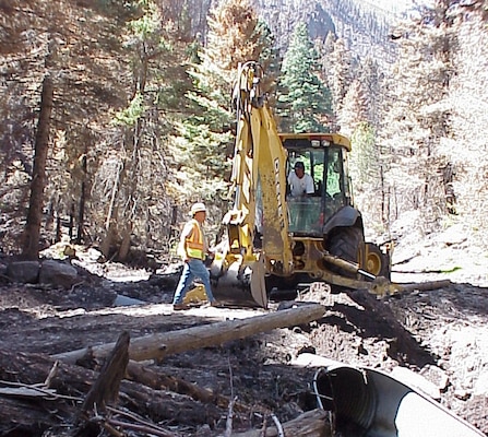 Joseph Lopez and Roger Apodaca, District’s Abiquiu Lake equipment operators, narrowly escaped a flash flood while steadily maneuvering heavy equipment owned by the Corps to help clear debris from a flooded area of Santa Clara Canyon. 
