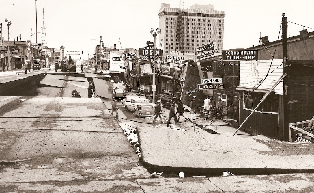 Emergency response workers survey damage on Fourth Avenue between C and D streets in downtown Anchorage after a Magnitude 9.2 earthquake occurred in Alaska March 27,1964. The earthquake prompted a joint effort by military and civil authorities involving rescue and reconstruction work that is unparalleled in Alaska’s history. Army engineers provided emergency relief, cleared debris, restored public facilities, conducted scientific data and interviewed survivors.