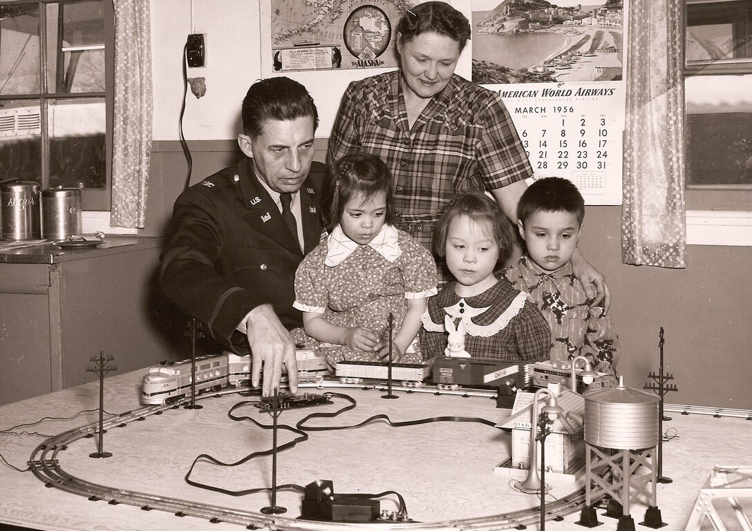 Former Alaska District Commander Col. Carl Y. Farrell (May 1, 1954-May 30, 1956) helps orphans at the Valley Christian Home for Children operate a toy train. Mrs. Harold A. Richards, who with her husband supervised the facility, looks on. Farrell and district employees visited in 1956 to deliver Easter baskets. The District Engineer Orphan Fund was established in 1948 to aid the home near Palmer. Employees donated 25 cents or more each pay day to the effort. By 1958, the district had raised $26,000 to help purchase washing machines, a dryer, bunk beds and the drilling of a new water well, in addition to holiday gifts and food. The Territory of Alaska placed the youngsters in the home and provided a monthly payment for each child. All other expenses were covered by charitable donations. (Public Affairs Historical Files)