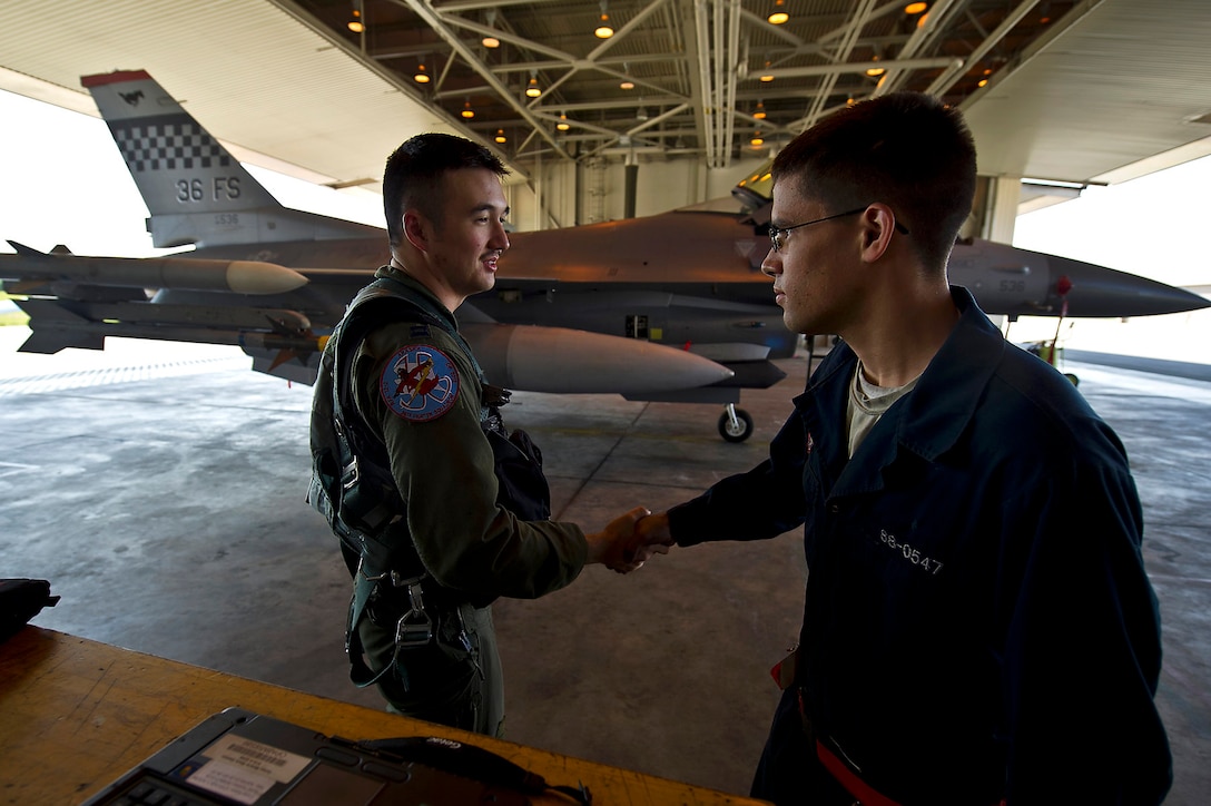 U.S. Air Force Capt. Shannon Beers shakes hands with Airman 1st Class William Orlandi after completing a combat-training mission during Red Flag-Alaska 12-2 on Eielson Air Force Base, Alaska, June 18, 2012. Beers, an F-16 Fighting Falcon pilot assigned to the 36th Fighter Squadron, and Orlandi, a crew chief  assigned to  the 51st Aircraft Maintenance Squadron, are based on Osan Air Base, South Korea.