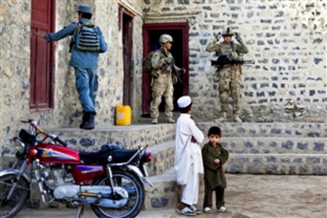 U.S. soldiers and Afghan policemen search for weapons caches in the village of Loy Murghoz in Afghanistan's Khowst province, June 8, 2012.