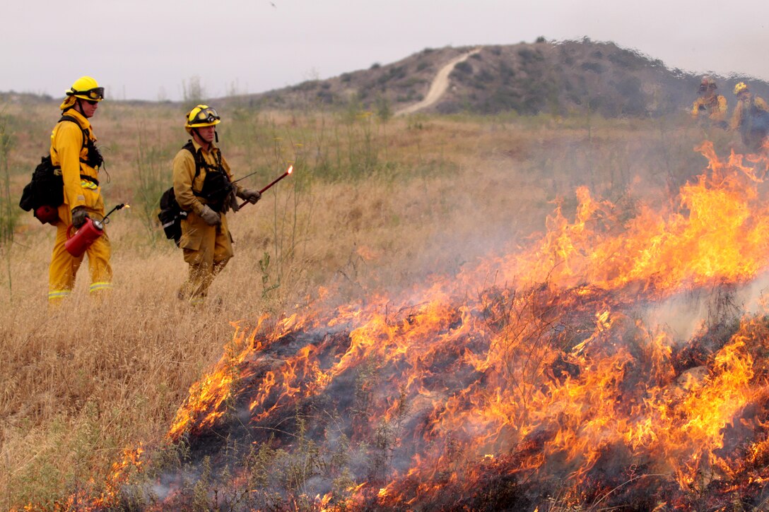 Instructors watch a controlled burn’s behavior during this year’s wild land fire training exercise on Camp Pendleton, June 15. The training not only affected those battling the fires on the ground but also gave an opportunity for the fire departments’ chiefs and commanders, who were supervising the training procedures from on top of hills, to practice where to disperse their men and study how the fires spread aboard the base.