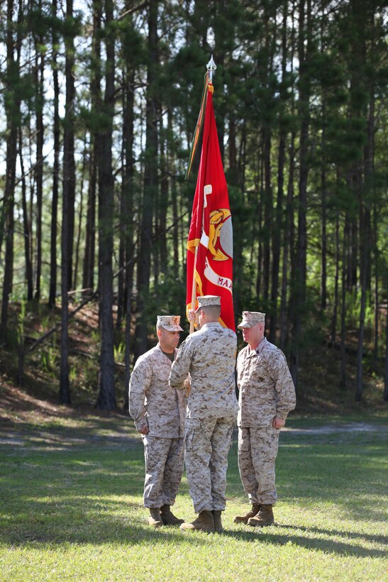 Lt. Col. Ivan I. Monclova, center, transfers the colors to Lt. Col. Carlos A. Vallejo, left, during a change of command ceremony aboard Stone Bay June 15. Monclova relinquished command as commanding officer of Weapons Training Battalion, Marine Corps Installations East – Marine Corps Base Camp Lejeune.