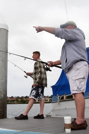 Petty Officer 1st Class Mathew E. Hayes,(left) shipboard damage control, Naval operations Support Center Coronado, Calif., examines his cast with his father, Cliffton Ray Trussel, during Fish or Boat with Dad Day June 16 aboard Marine Corps Recruit Depot San Diego. The event has been a tradition aboard MCRD for 17 years and has allowed fathers to spend an enjoyable time with their families. 