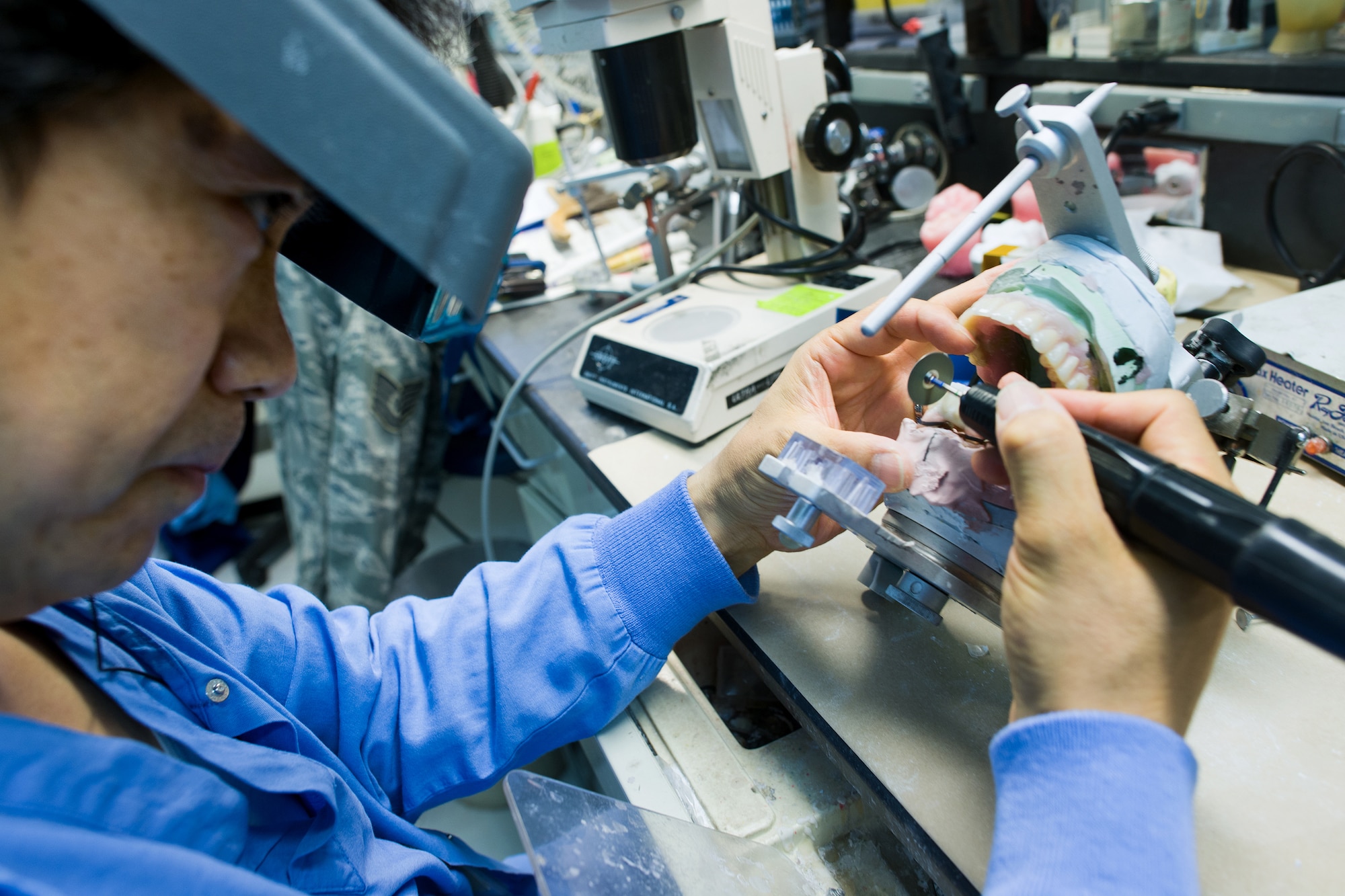 YOKOTA AIR BASE, Japan -- Fujio Ishikawa, 374th Dental Squadron dental laboratory technician, grinds a tooth's outline in the dental lab at Yokota Air Base, Japan, on June 19, 2012. Ishikawa has worked at the Yokota dental lab for 23 years. (U.S. Air Force photo by Osakabe Yasuo)
