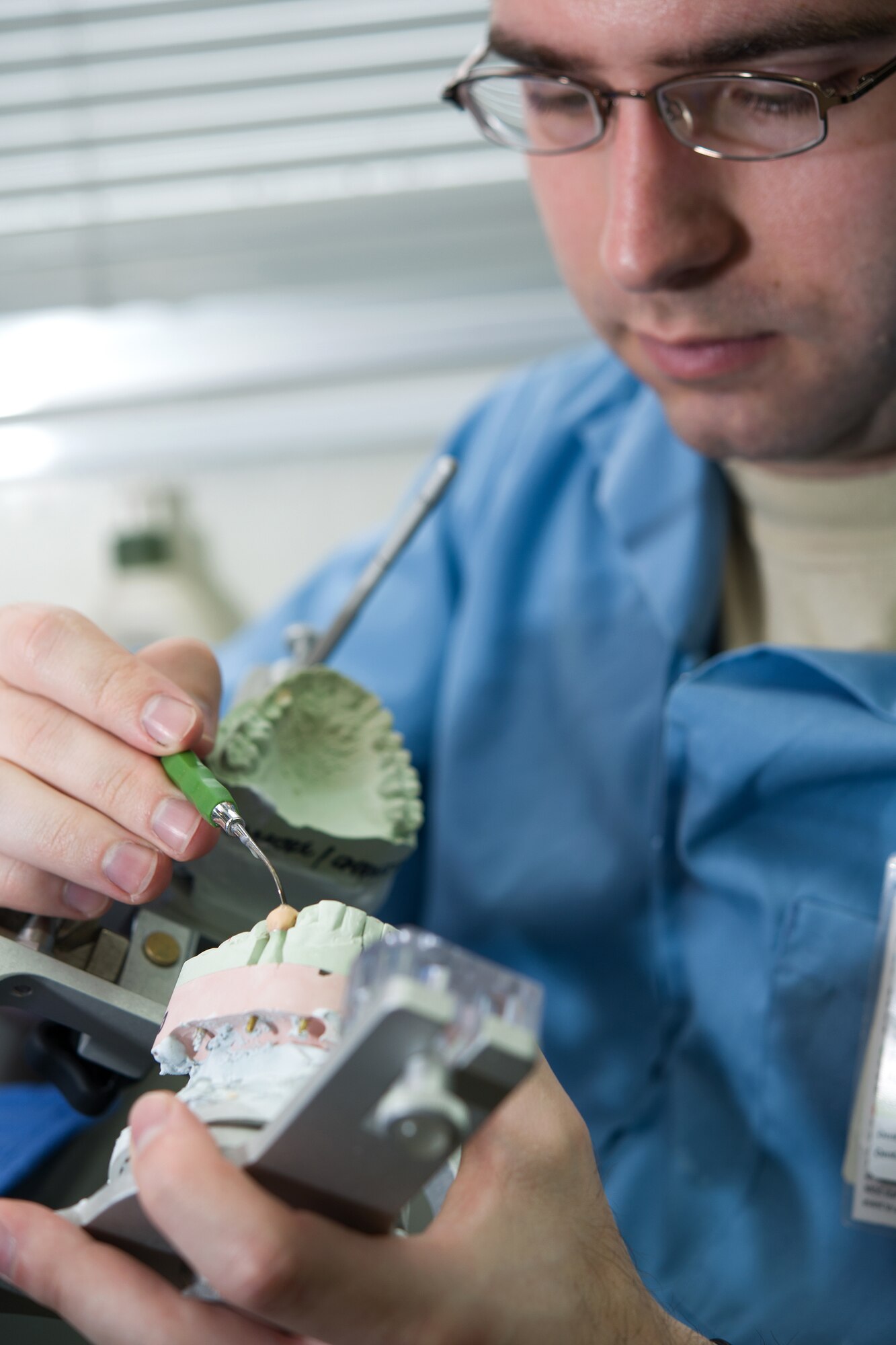 YOKOTA AIR BASE, Japan -- Senior Airman Adam Fowler, 374th Dental Squadron dental laboratory technician, waxes a crown in the dental lab at Yokota Air Base, Japan, on June 19, 2012. The dental lab makes full dentures, caps, implants and veneers for patients in need. (U.S. Air Force photo by Osakabe Yasuo)