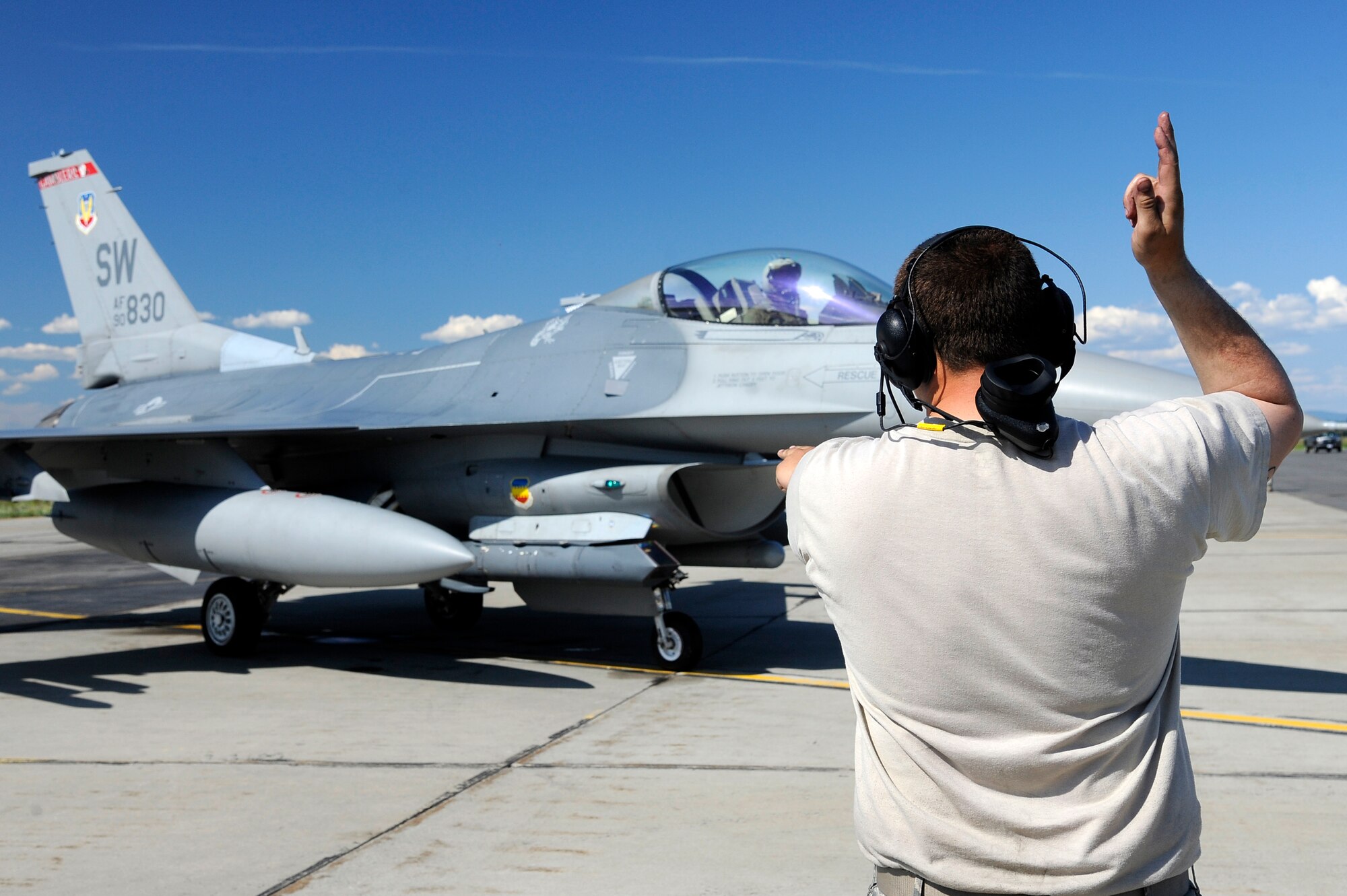 U.S. Air Force Airman 1st Class Max Stammer, 77th Aircraft Maintenance Unit crew chief out of Shaw Air Force Base, S.C., marshals an F-16 Fighting Falcon during RED FLAG-Alaska 12-2  June 19, 2012, Eielson Air Force Base, Alaska. RF-A provides training for deployed maintenance and support personnel in sustainment of a large-force deployed air operation. (U.S. Air Force photo/Staff Sgt. Jim Araos)