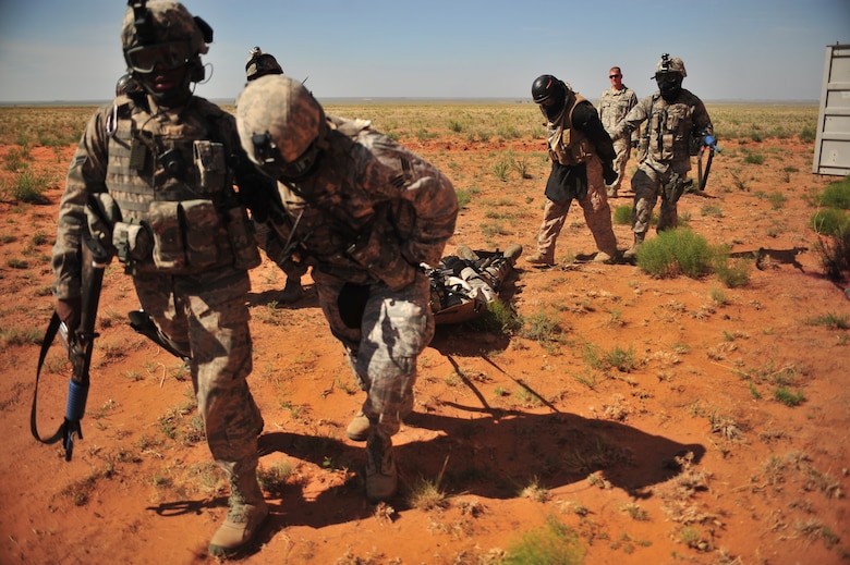 U.S. Air Force Airman 1st Class Shaquell Nurse and Senior Airman Jared Almengor, 27th Special Operations Security Forces Squadron Deployed Aircraft Ground Response Element team, pull Staff Sgt. Douglas Freeman, 27 SOSFS DAGRE, on a litter during a convoy training mission at Melrose Air Force Range, N.M., June 8, 2012. The DAGRE team is trained to adapt security missions to support Special Operations Forces worldwide. (U.S. Air Force photo by Airman 1st Class Eboni Reece)