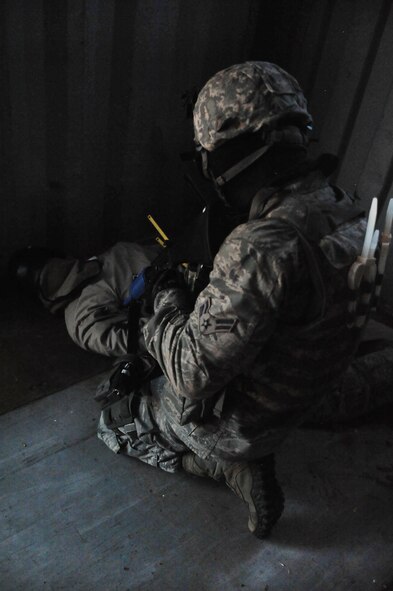 U.S. Air Force Airman 1st Class Steven Viola, 27th Special Operations Security Forces Squadron Deployed Aircraft Ground Response Element team, kneels down while watching a captured opposing forces member during a convoy training mission at Melrose Air Force Range, N.M., June 8, 2012. The DAGRE team is trained to adapt security missions to support Special Operations Forces worldwide. (U.S. Air Force photo by Airman 1st Class Eboni Reece)