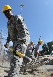 Master Sgt. H. Mylo Gibson II, 51st Combat Communications Squadron first sergeant, helps a member of his squadron prepare the earth for an equipment grounding configuration. Gibson was selected as the Air Force’s 2012 First Sergeant of the Year. (U.S. Air Force photo by Robert Talenti)