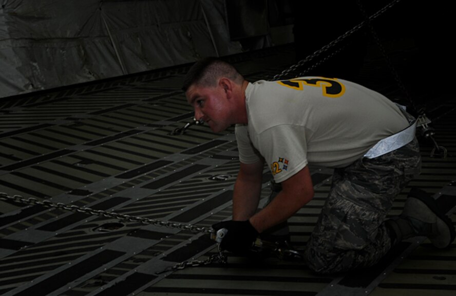 Tech. Sgt. Todd Losch Jr., 32nd Aerial Port Squadron air transportation specialist, tightens a chain that will secure a Humvee to the floor of a C-5 Galaxy static during the third phase of the cargo restraint event, which is part of the Port Dawg Challenge competition at Dobbins Air Reserve Base, Ga., June 20, 2012. The cargo restraint event judges “Port Dawgs” abilities to properly calculate the restraints required for transporting cargo and applying the restraints on the load to be shipped. (U.S. Air Force photo by Senior Airman Joshua J. Seybert/Released)