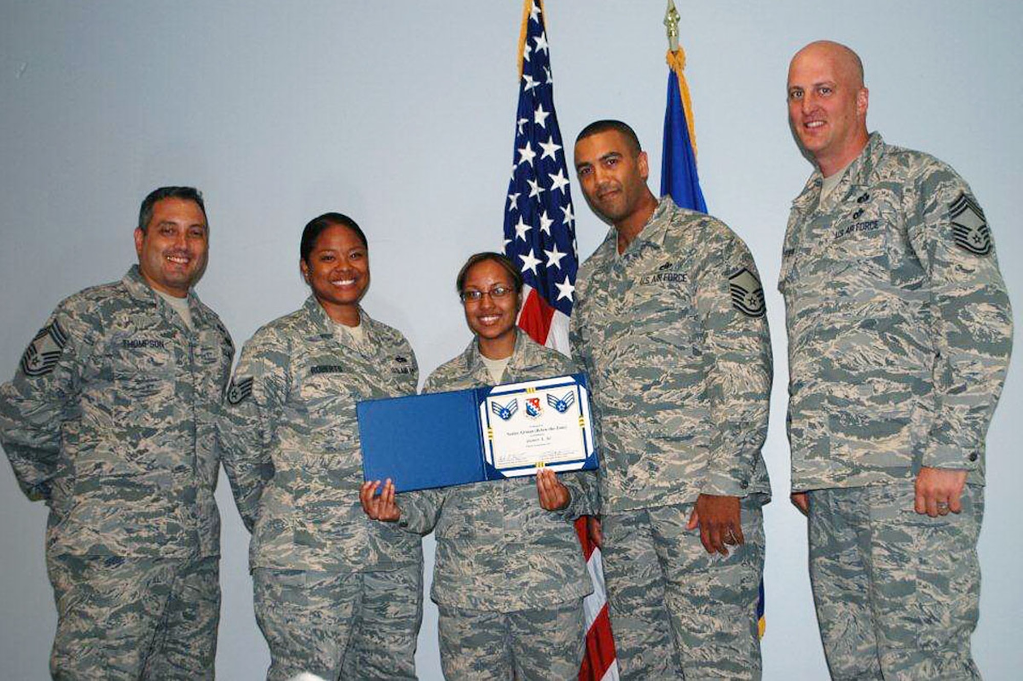 Airman 1st Class Yasmin Ali (center), Joint Personnel Property Shipping Office-Northeast storage management, shows off her certificate after being notified of selection for promotion to Senior Airman Below-the-Zone June 13. Also shown in the picture are (from left to right) Chief Master Sgt. Joe Thompson, Staff Sgt. Sandra Roberts, Master Sgt. Kevin Burrell and Chief Master Sgt. Baird Stiefel. Ali’s promotion is effective Sept. 8.