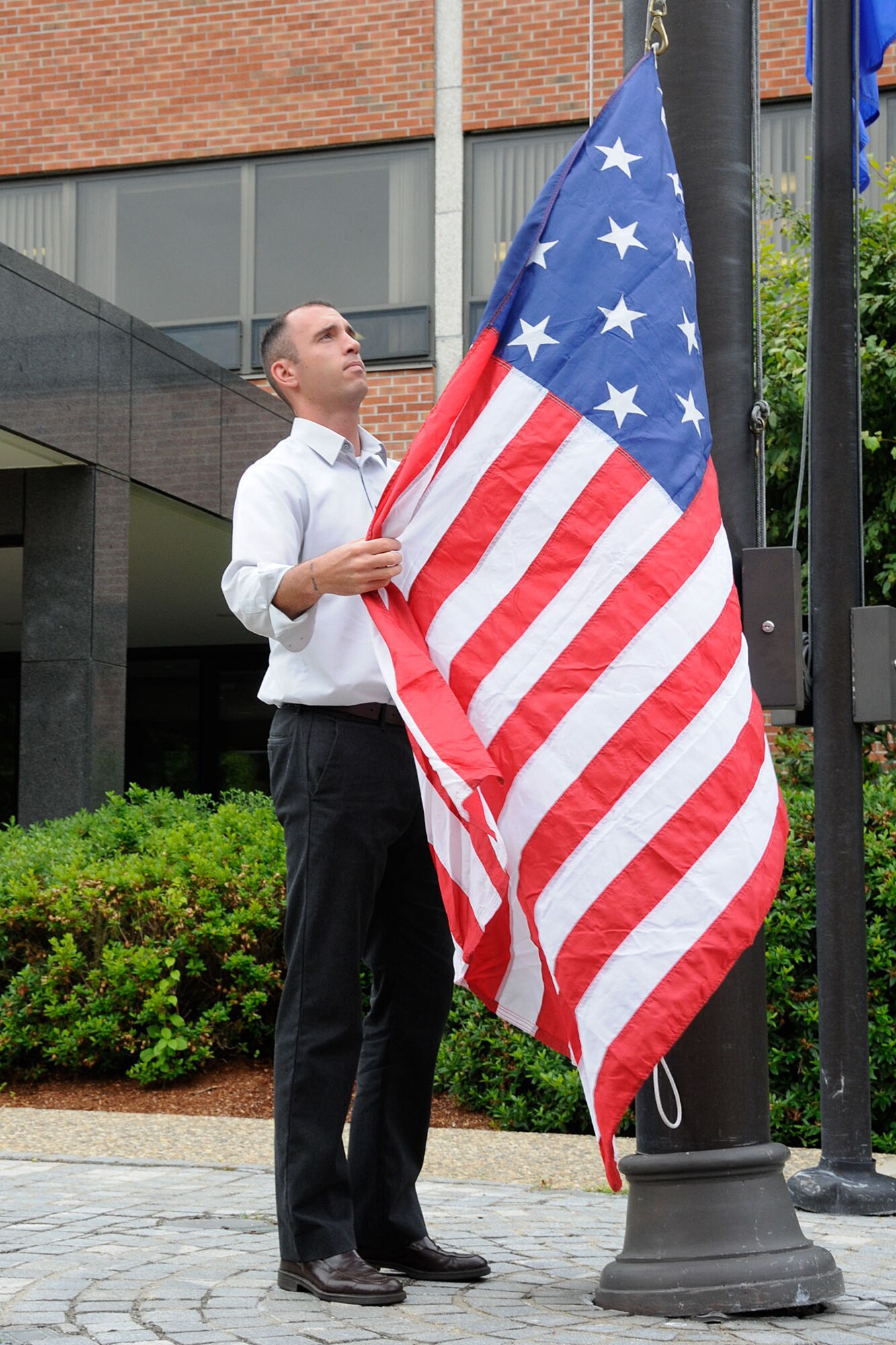 HANSCOM AIR FORCE BASE, Mass. – Phil Blanchard, Protocol chief, hoists a replica of the American flag from the 1812 time period in front of the Electronic Systems Center headquarters building on June 18, the 200 year anniversary of the beginning of the War of 1812. This particular flag has flown on several U.S. ships several military bases across the country and will eventually be put on permanent display in an American Legion Post in Florida. (U.S. Air Force photo by Linda LaBonte Britt)  