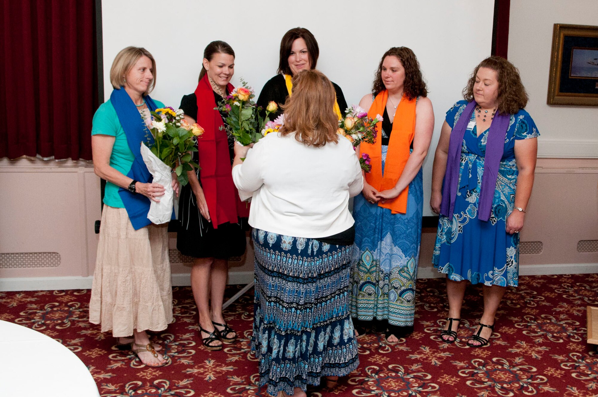 HANSCOM AIR FORCE BASE, Mass. - Nancy Delory, Hanscom Spouses Club parliamentarian, presents flowers to incoming board members for 2012 and 2013 at the Minuteman Commons June 15. New board members pictured are (left to right) Barb Hiltz, secretary; Rebecca Alonso, welfare treasurer; Noel Grabell, second vice president; Erin Anderson, first vice president; and Betsy Woolums, president. (U.S. Air Force photo by Mark Wyatt)