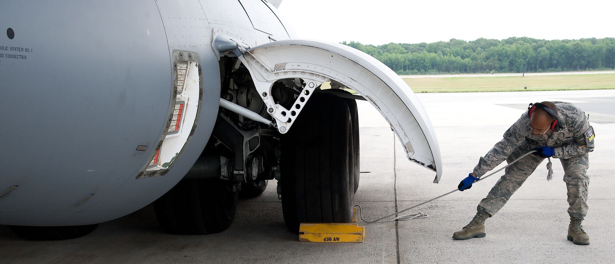 Senior Airman Jeremy Gaither, a crew chief with the 712th Aircraft Maintenance Squadron, removes a chock before the start of a C-17 Globemaster III training mission June 19, 2012, at Dover Air Force Base, Del. Team Dover frequently flies training missions to ensure flight members remain at optimal mission readiness. (U.S. Air Force photo by Adrian R. Rowan)