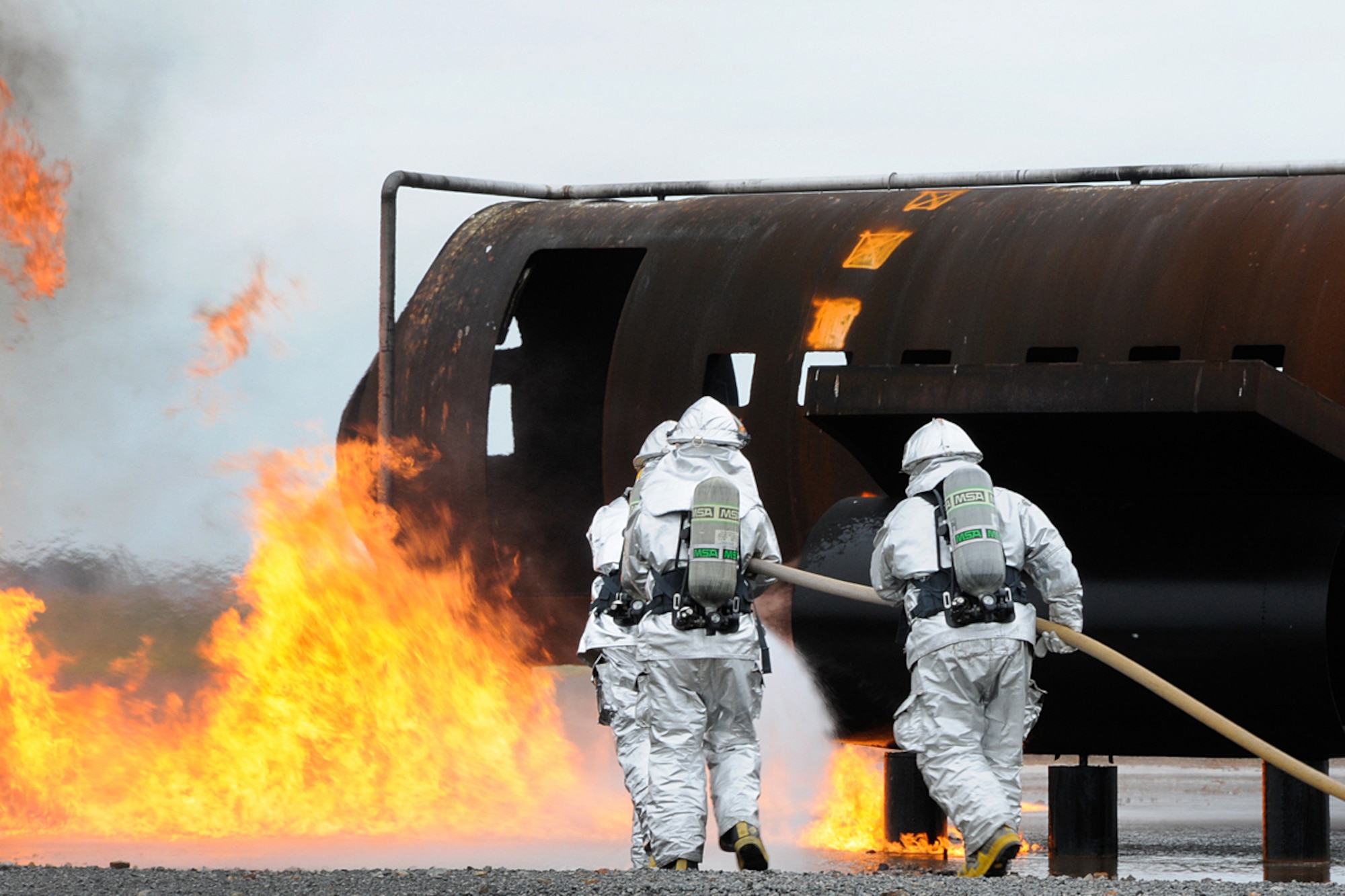 BOSTON -- Hanscom firefighters use a water fog stream to push fire off fuel during a training exercise at Logan International Airport June 19. The training provides realistic experiences for the firefighters should a similar event happen locally. (U.S. Air Force photo by Linda LaBonte Britt)