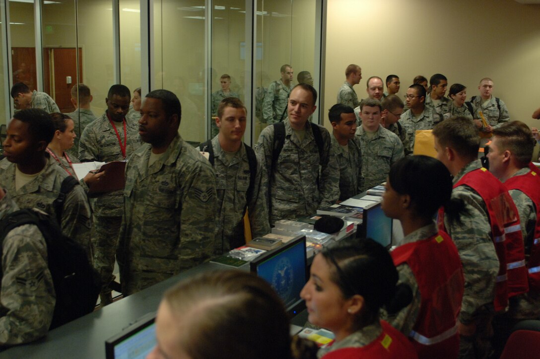 Airmen process through a Personnel Deployment Function line during an Operational Readiness Exercise in the new deployment center at Ellsworth Air Force Base, S.D., June 15, 2012. The PDF line allows deployers a last chance to verify information and create important documents including wills and powers of attorney. (U.S. Air Force photo by Airman 1st Class Zachary Hada/Released)