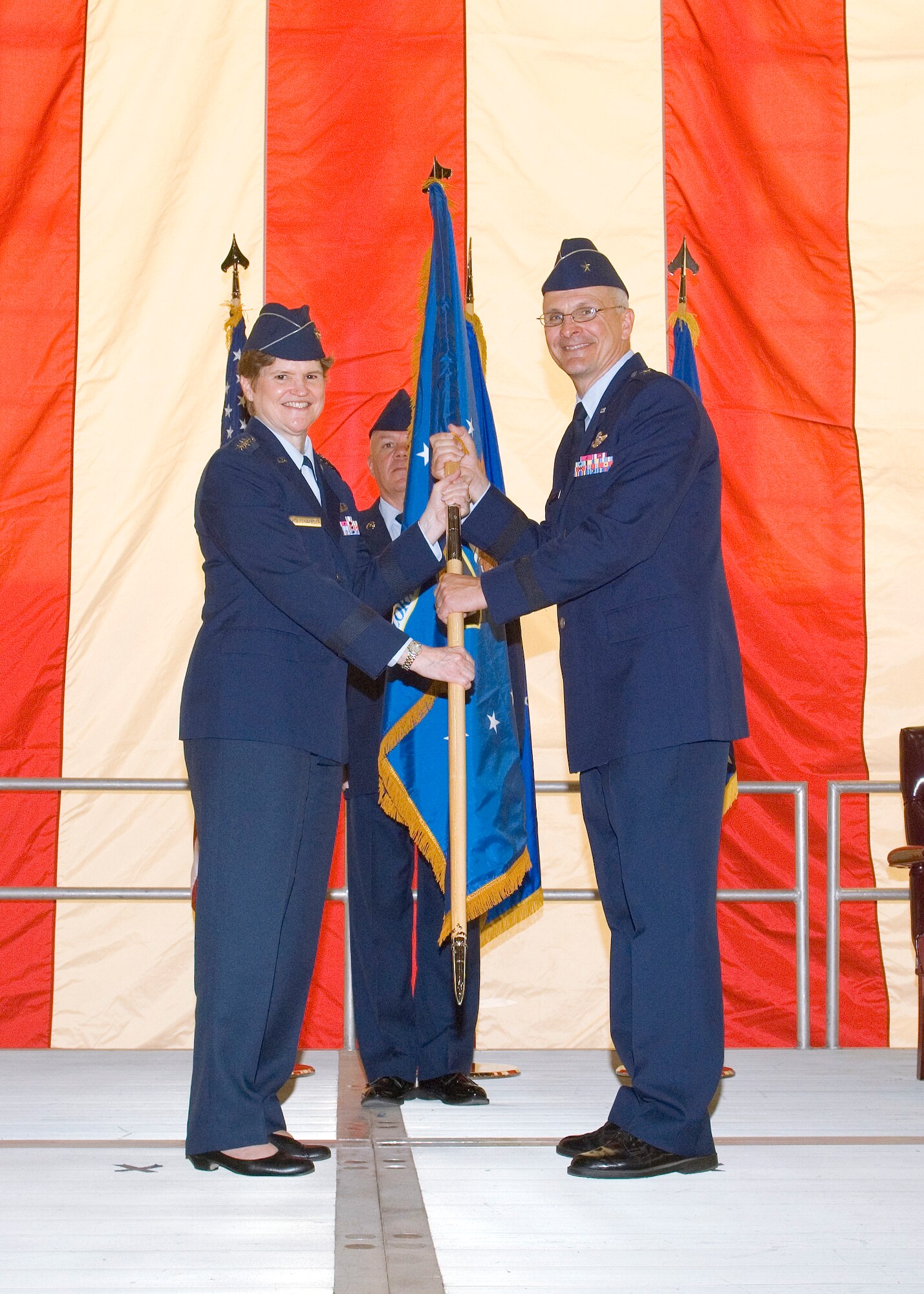 (Left) Gen. Janet Wolfenbarger, Air Force Materiel Command commander, hands Brig. Gen. Arnold W. Bunch Jr. the Air Force Flight Test Center guideon during the AFFTC change-of-command ceremony held June 19 in Hangar 1600. General Bunch took command of the AFFTC from Brig. Gen. Robert C. Nolan II during the ceremony. (U.S. Air Force photo by Edward Cannon)