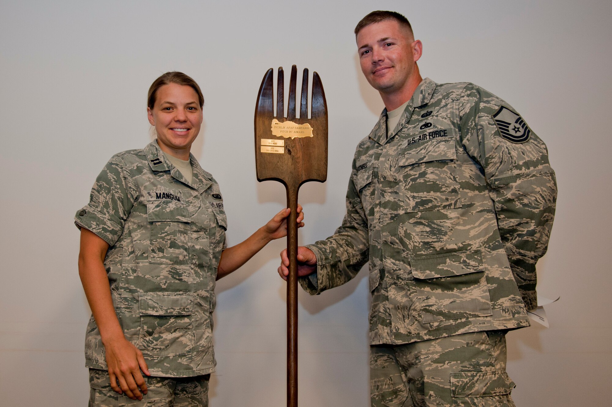 Master Sgt. James Mitchell, 39th Air Base Wing Air Force Assistance Fund assistant installation project officer, presents the Incirlik AFAF Campaign Pitch Fork Award to Capt. Mary Mangum, 39th Comptroller Squadron financial analyst flight commander, June 19, 2012, at Incirlik Air Base, Turkey. Mangum accepted the award on behalf of the 39th CPTS and 39th Air Base Wing, Wing Staff Agencies for raising more than $500 during the AFAF American Forces Radio and Television Service telethon. (U.S. Air Force photo by Senior Airman Anthony Sanchelli/Released)
