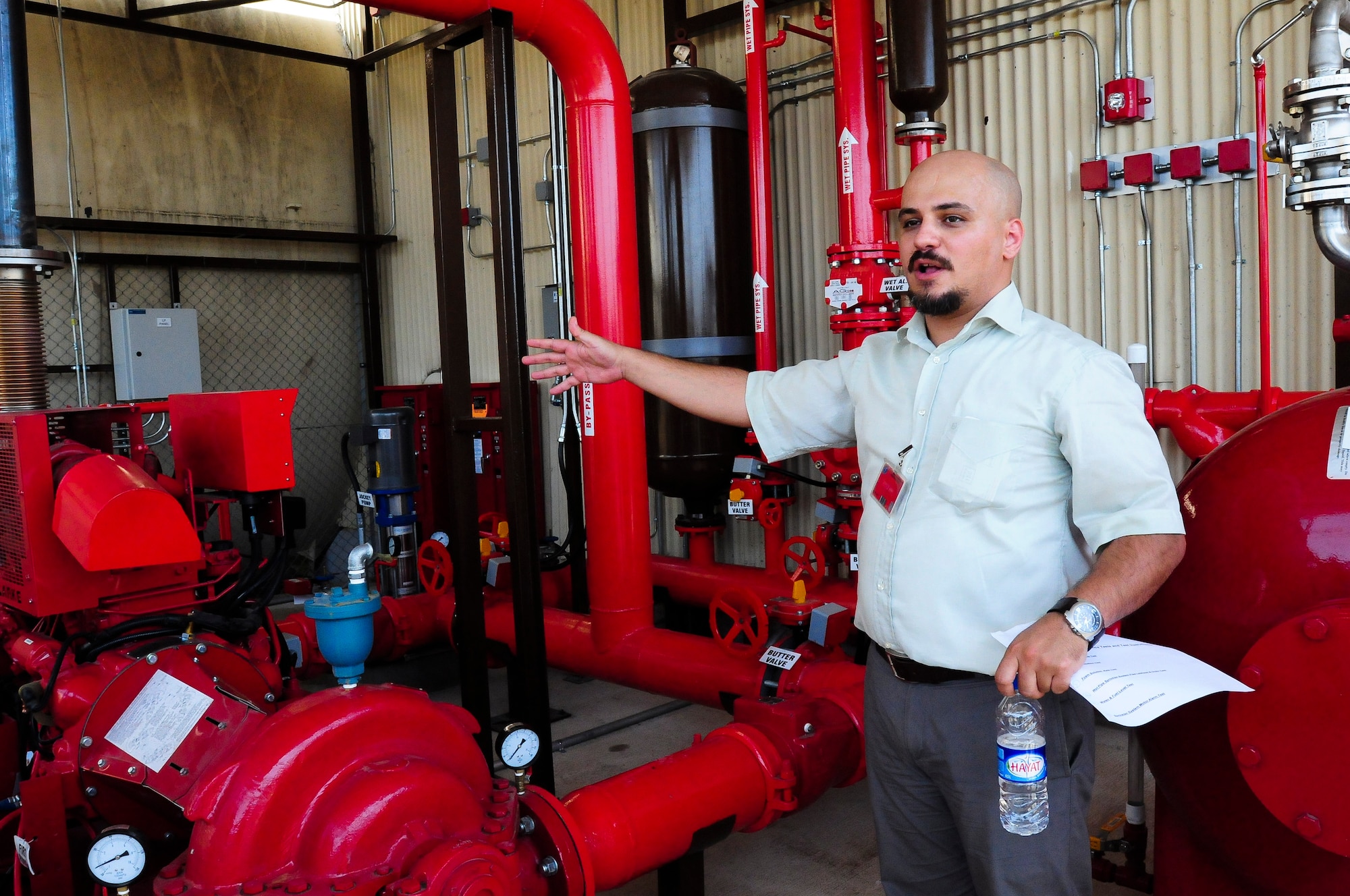 Deurim Budak, a fire engineer and lead for the installation of a new fire suppression system for the 414th Expeditionary Reconnaissance Squadron, explains how the system works during the final test and certification of the system June 15, 2012, at Incirlik Air Base, Turkey. The new system took about three months to install and is part of a bigger plan to improve the facilities for the 414th ERS. (U.S. Air Force photo by Capt. Gina McKeen/Released)