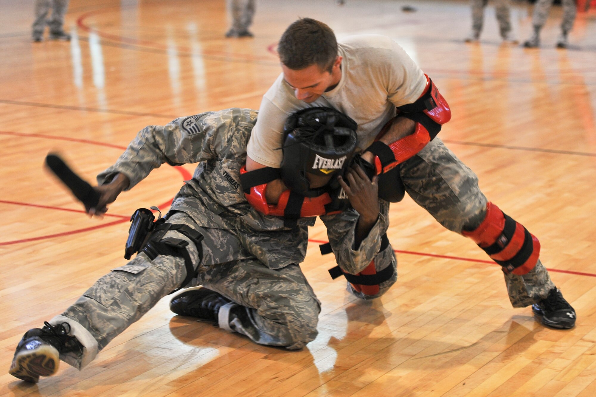 Staff Sgt. Perry Vitali puts Staff Sgt. Aaron Thomas in a head lock during baton training at the Osan Air Base fitness center, June 19, 2012. During the course, newly assigned security forces Airmen learn muscle memory skills with the baton and fight with an aggressor to help them understand the situations they may face that require them to use non-lethal force. (U.S. Air Force photo/Staff Sgt. Stefanie Torres)