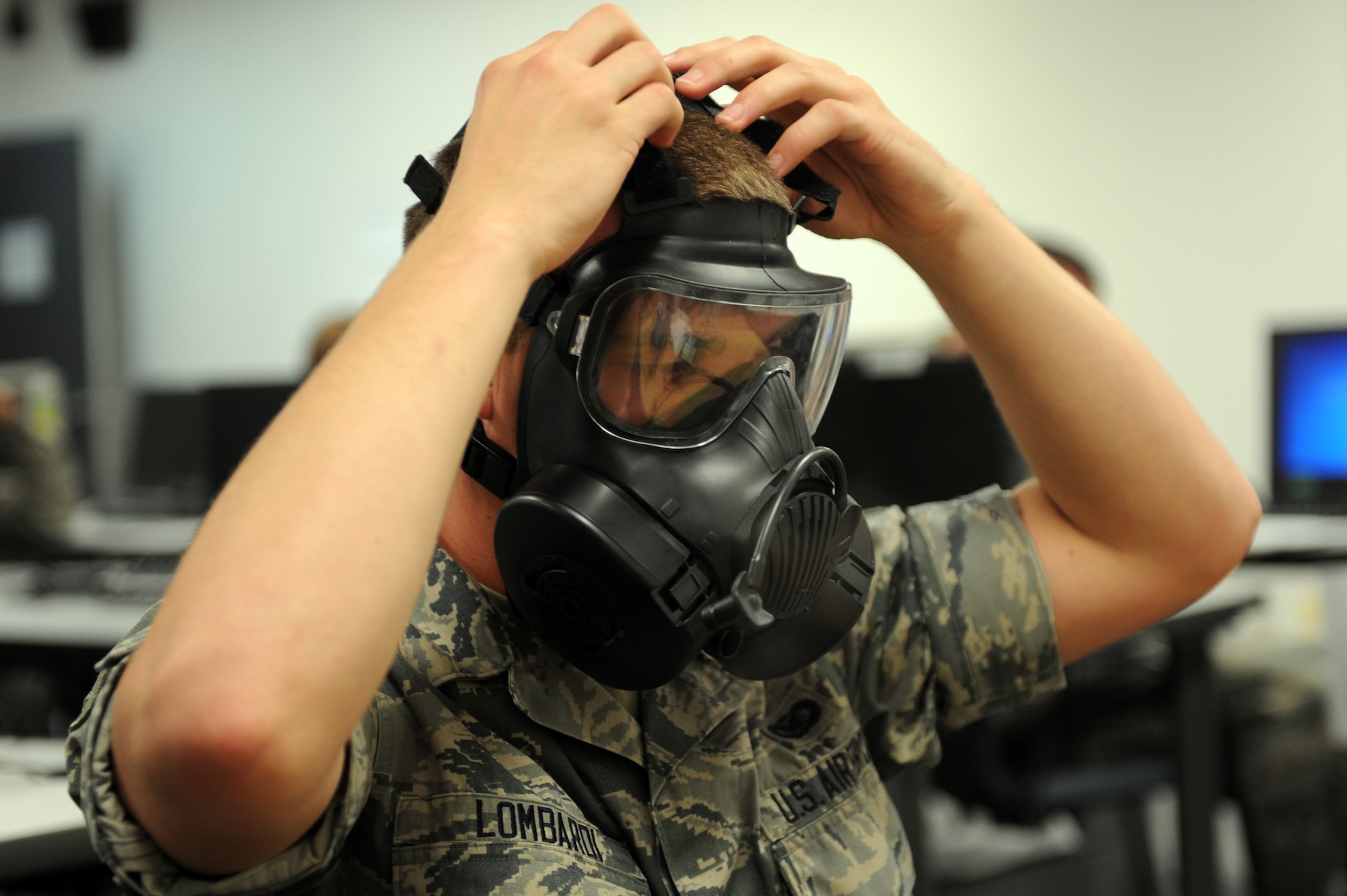 U.S. Air Force Airman 1st Class Jacob Lombardi, 35th Fighter Wing Public Affairs broadcaster, adjusts a gas mask during a quantitative fit-test at Misawa Air Base, Japan, June 20, 2012. The QNFT method determines the proper size and fit of the mask on servicemembers. (U.S. Air Force photo by Airman 1st Class Kia Atkins/Released)