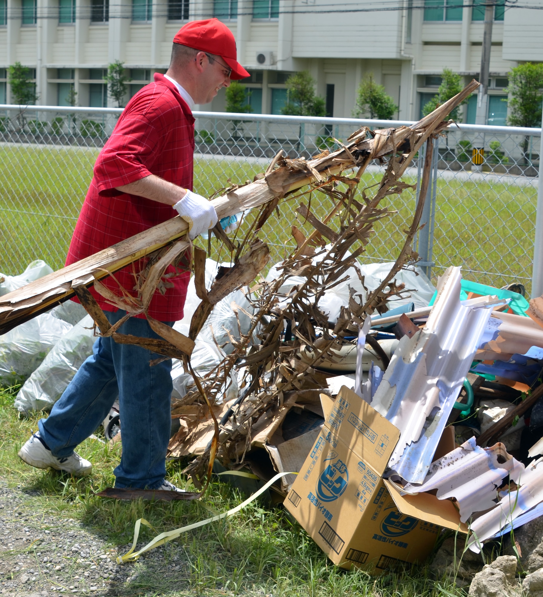 U.S. Air Force Tech. Sgt. Rob Nassef, Henry E. Erwin Professional Military Education Center Class 12-05 student, carries a dead Palm tree to a trash pile at the Ichijoen Elders Home June 16, 2012. Twenty seven members of Class 12-05 visited the elder’s home for an afternoon of lawn work during a volunteer community relations activity. Nassef is a member of the 35th Fighter Wing Misawa Air Base, Japan. (U.S. Air Force photo by Tech. Sgt. Larry Adams/Released) 