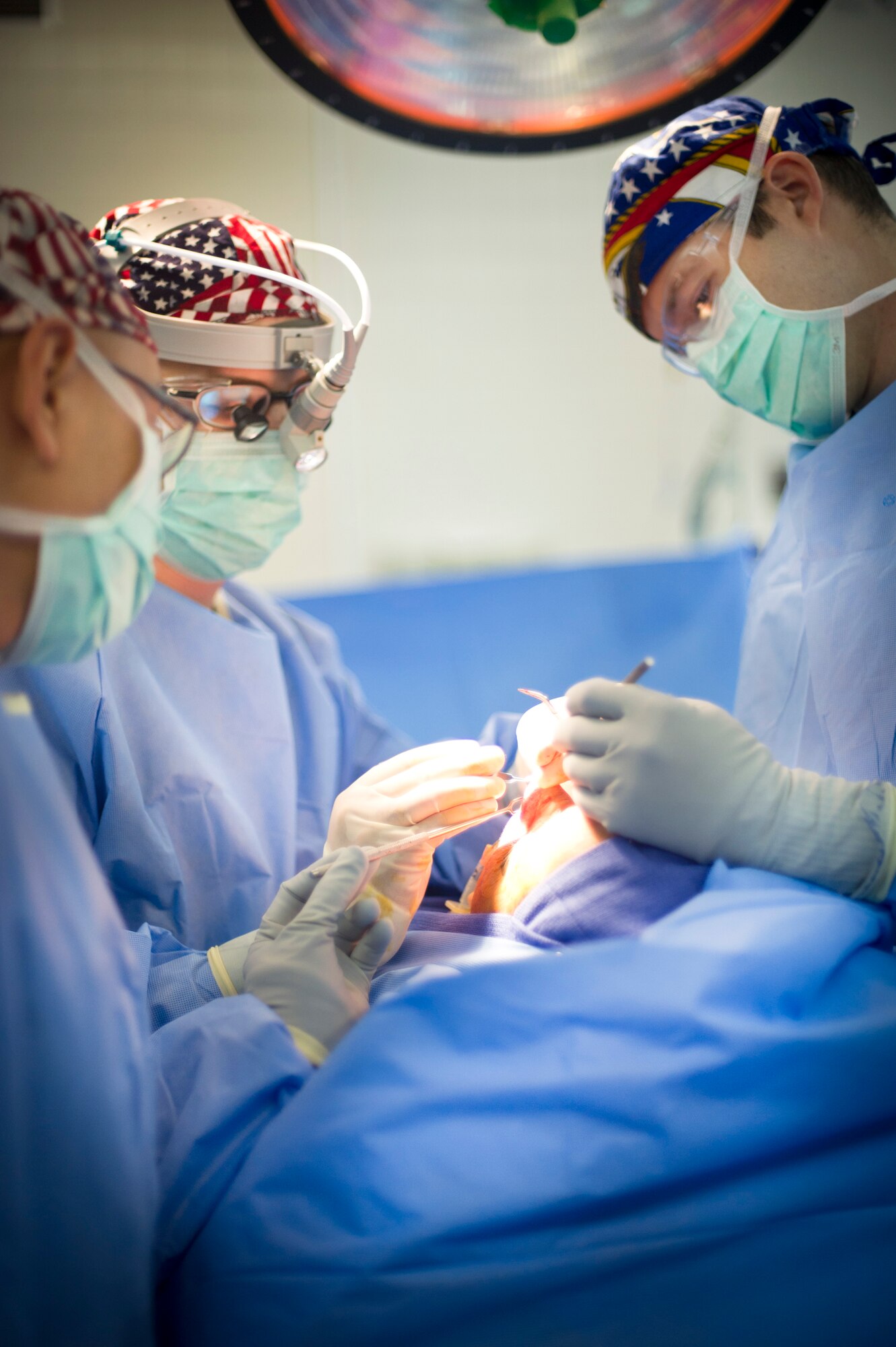 YOKOTA AIR BASE, Japan -- Maj. (Dr.) Scott McCusker, right, 374th Medical Operations Squadron chief of otolaryngology, and Maj. (Dr.) Leland Webb, center-left, 374 MDOS chief of general surgery, dissect Staff Sgt. Flor Rocha's nose during a rhinoplasty operation at Yokota Air Base, Japan, June 11, 2012. McCusker performed the operation to fix a breathing problem caused by a previous rhinoplasty operation. (U.S. Air Force Photo by Staff Sgt. Stacy Moless)