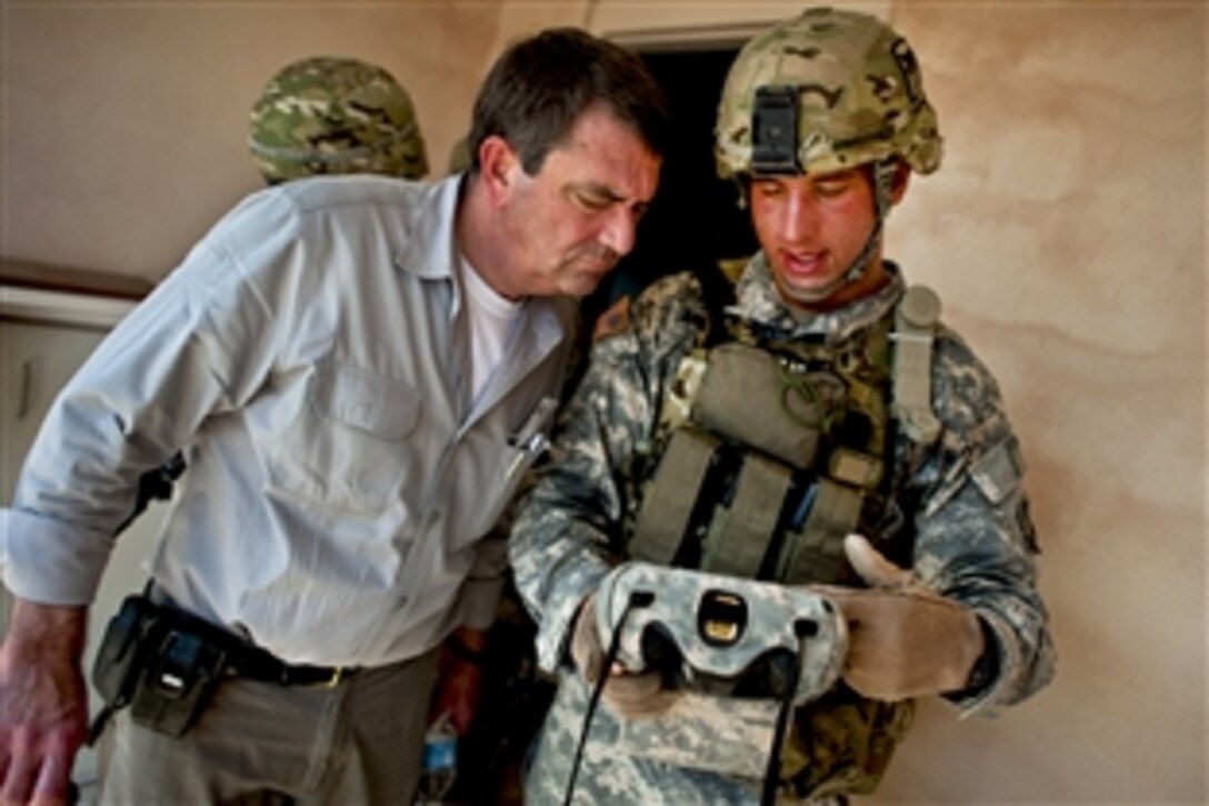 U.S. Army Sgt. Donald Armstrong explains a biometric scanning system to Deputy Defense Secretary Ashton B. Carter during a training exercise to counter improvised explosive devices, or IEDs, on Fort Campbell, Ky., June 20, 2012. Armstrong is assigned to the 101st Airborne Division.