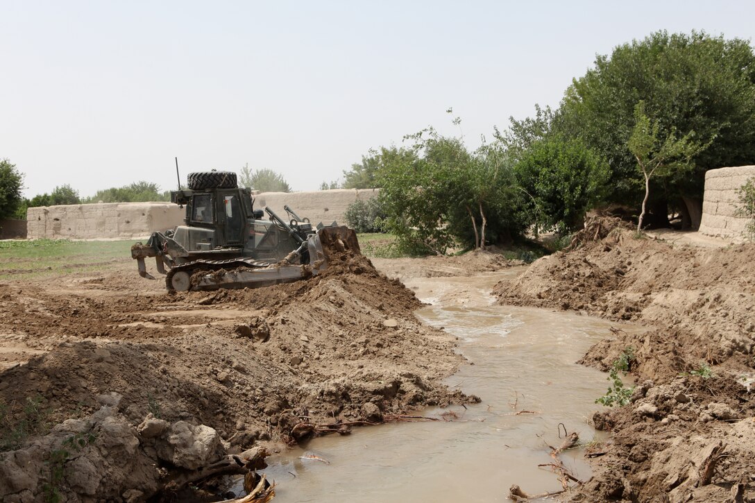 A heavy equipment operator from 8th Engineer Support Battalion, 1st Marine Logistics Group (Forward) uses a Medium Crawler Tractor during the construction of a culvert at a village stability platform manned by special operations forces, June 21. “The heavy equipment operators put in a lot of time at the start of this mission, and they really adapted to the situation well,” said 1st Lt. Christopher White, platoon commander, Charlie Company, 8th ESB.