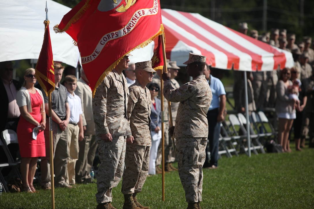 Sgt. Maj. Veney Cochran, command sergeant major of the Marine Corps Engineer School, presents the unit guidon to Col. Peter M. Ramey, who then will pass it to Lt. Col. Jeffrey J. Johnson to signify the change of command during the official change of command ceremony for the school aboard Marine Corps Base Camp Lejeune June 15. Ramey served as the school’s commanding officer for the last two years.