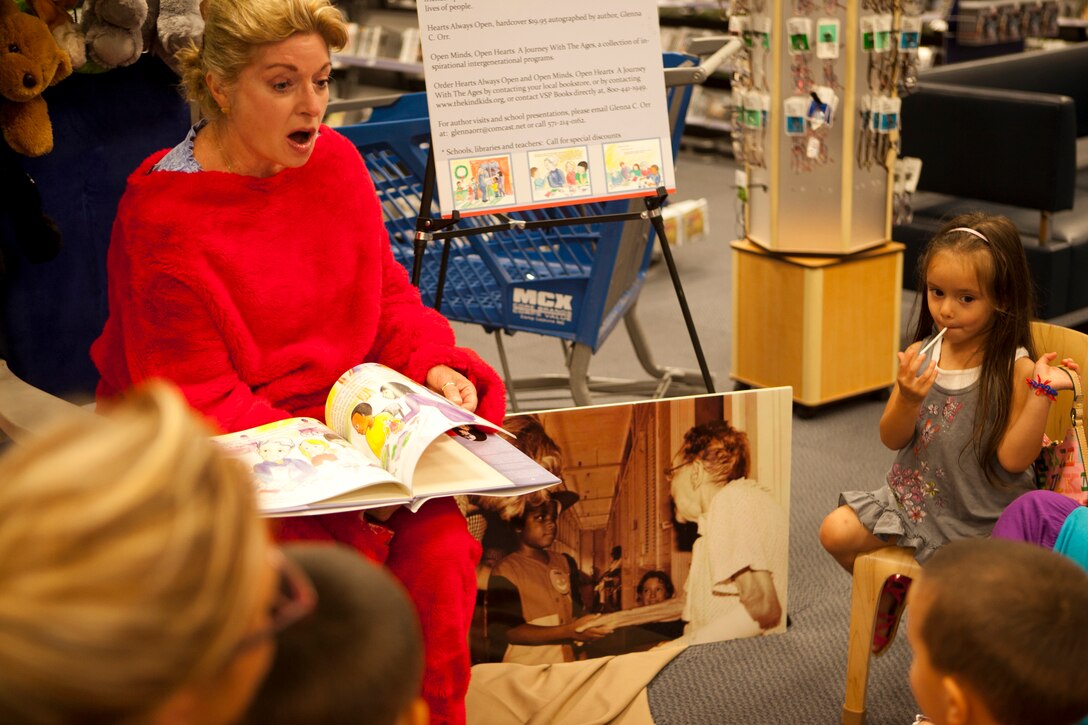 Glenna C. Orr, author of two books and 2011 Mom’s Choice Awards winner, reads one of her books to a group of children who have gathered around to listen during the book fair at the Marine Corps Exchange aboard Marine Corps Base Camp Lejeune June 16. Vast numbers of children came to visit Orr and listen to her books, and also to get a picture with her dressed as Clifford the Big Red Dog.