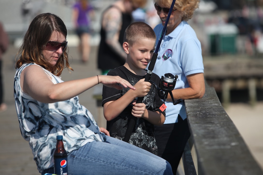 A child and his mother watch as they cast their line into the Atlantic Ocean in the hopes of catching of a fish during Step Up For Soldiers’ Children’s Fishing Tournament at Kure Beach June 9. The tournament was free for all who participated, and everything needed was provided by SUFS.