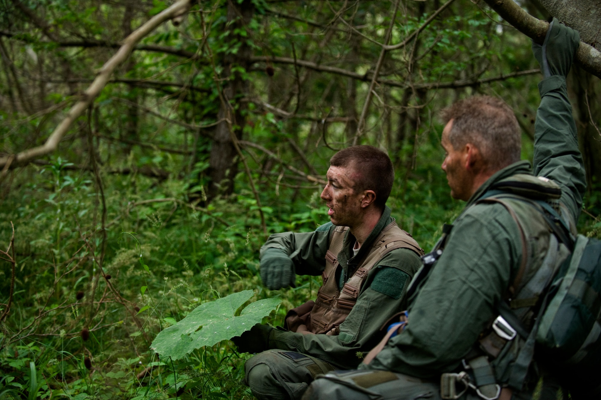 U.S. Air Force Senior Airman Michael Dixon, left, 35th Operations Support Squadron survival, evasion, resistance and escape specialist, explains basic evasion tactics to Chief Master Sgt. James Laurent, 35th Fighter Wing command chief, during SERE training at Draughon Range, Japan, June 20, 2012. Dixon spent the day and part of the night teaching critical skills needed to survive if isolated.  (U.S. Air Force photo by Staff Sgt. Nathan Lipscomb/Released) 