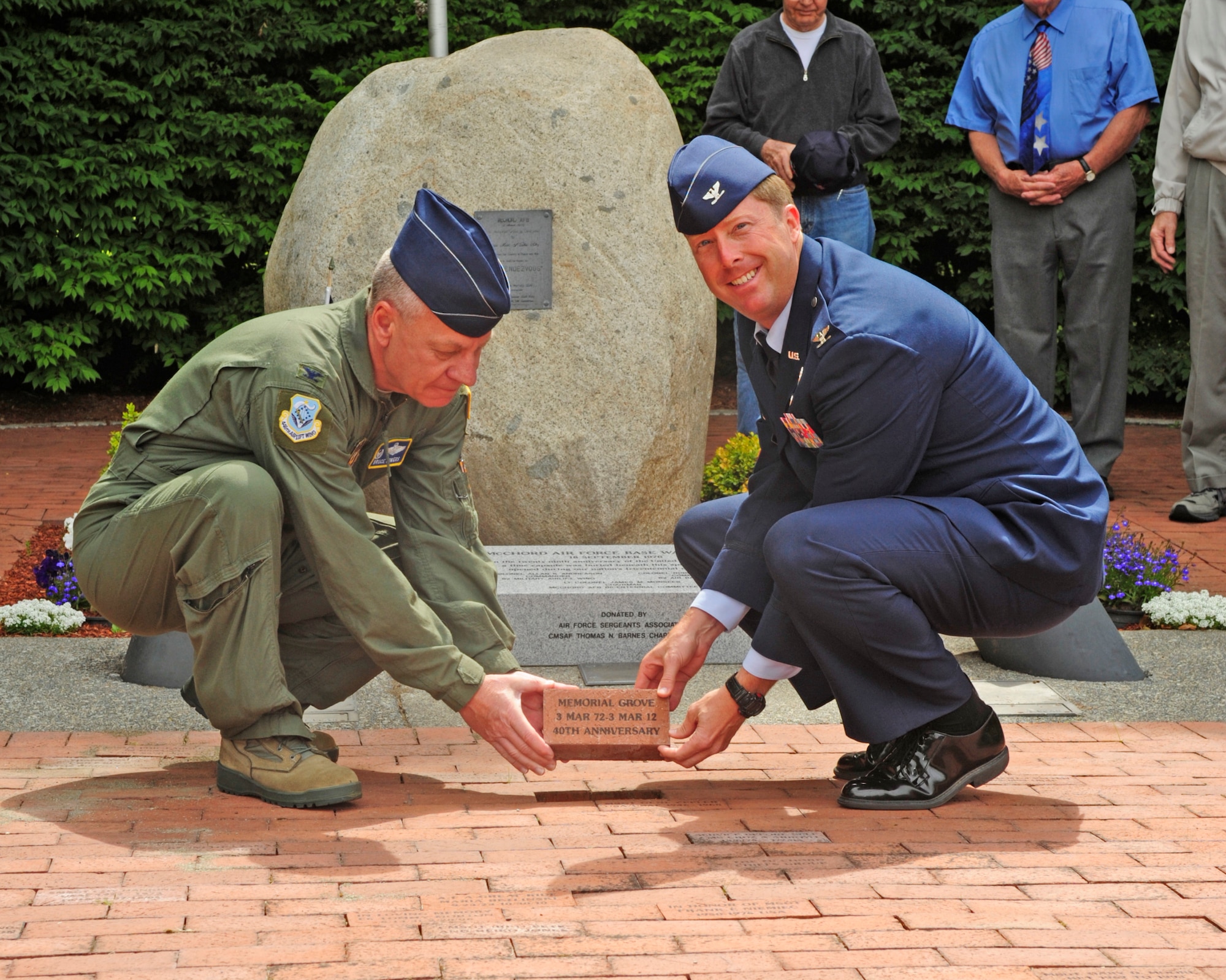 Col. Bruce Bowers, 446th Airlift Wing commander, and Col. Wyn Elder, 62nd Airlift Wing commander, place a brick commemorating the 40th anniversary of the founding of the Memorial Grove on McChord Field at Joint Base Lewis-McChord, Wash., June 21, 2012. (U.S. Air Force photo/Capt. Tawny M. Dotson)